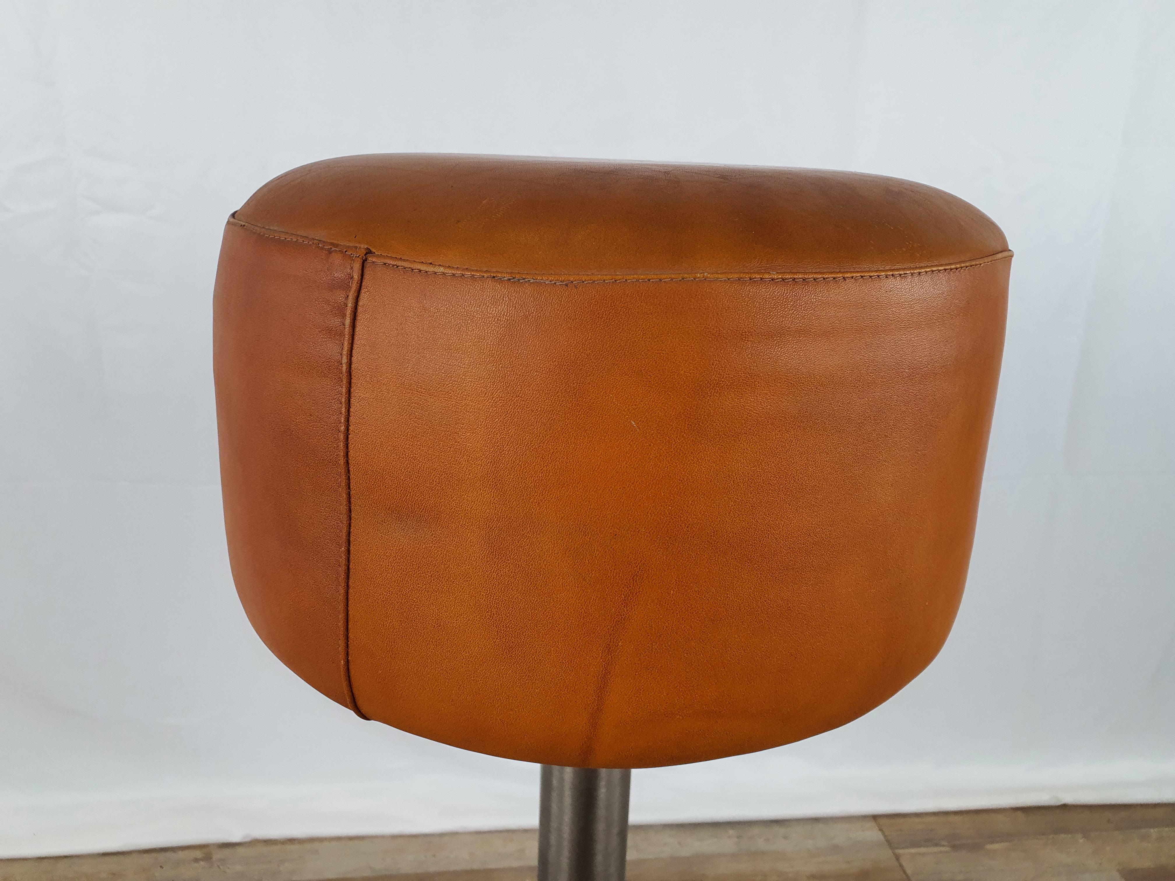 Metal stool from the early 1990s with circular seat in original orange leather and kept in perfect condition, as shown in the photos.

Very comfortable and rare to find, perfect for rooms or home kitchens with island or high dining