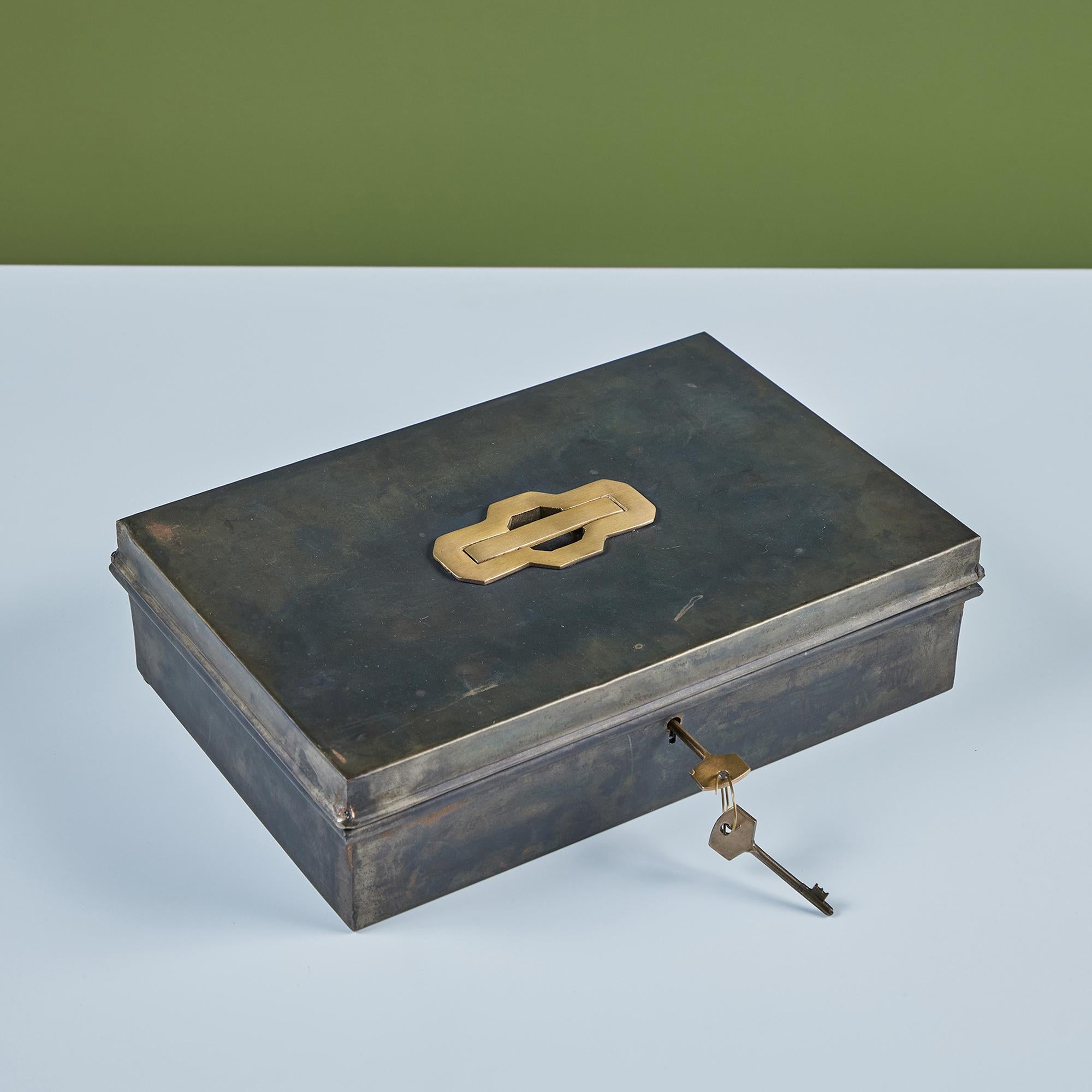Rechteckige Aufbewahrungsbox aus Metall mit einem ausziehbaren Messinggriff am Deckel der Box. Die Box wird mit einem Satz Messingschlüssel geliefert, um Ihre Wertsachen sicher aufzubewahren. 

Abmessungen
12