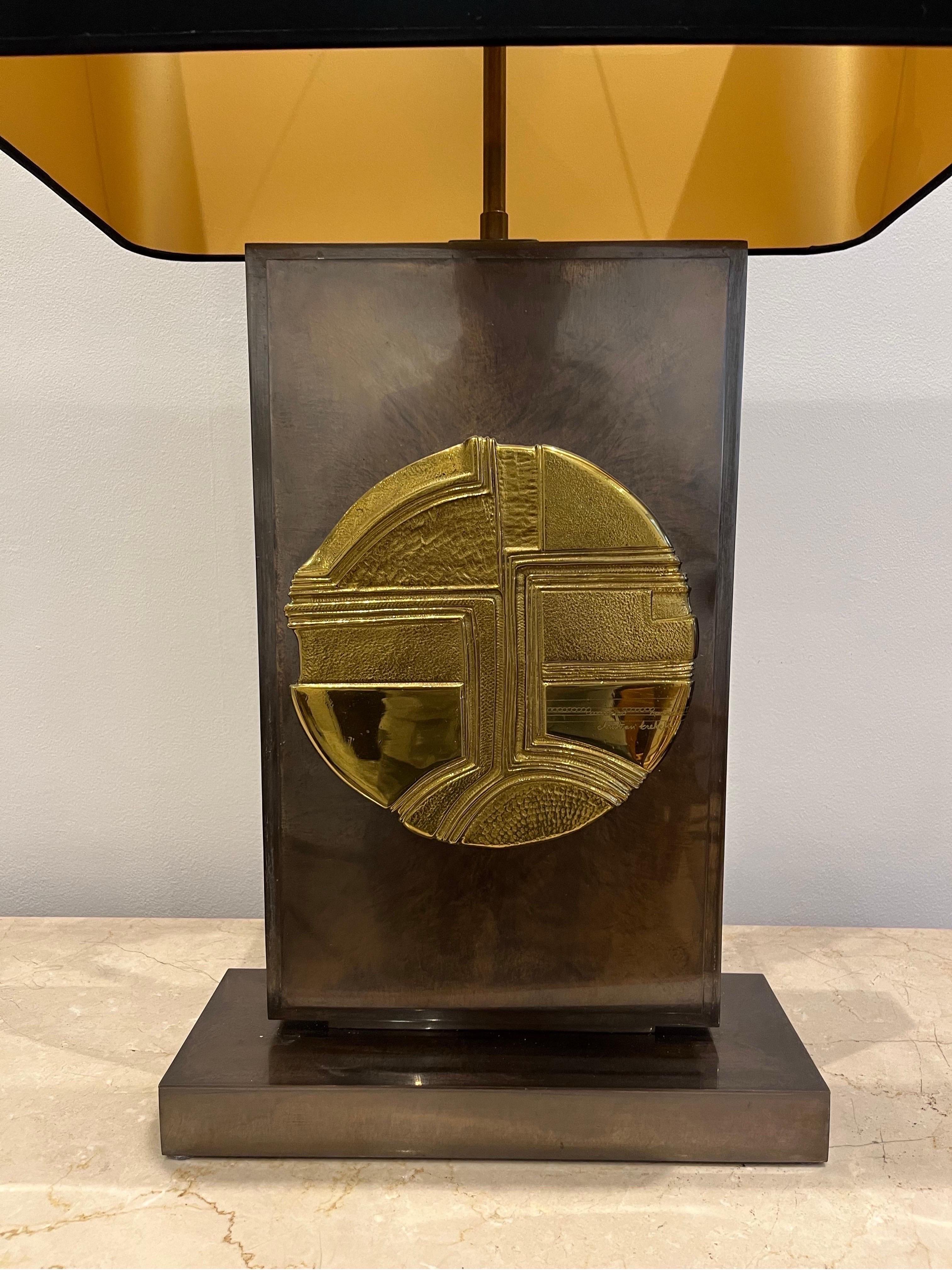 Christian Krekels is a Belgian designer who created decorative furniture from the 1970s. The present lamp is made of patinated metal. The shape is Rectangular. In the centre, there is the bronze gilt circle decorated with an abstract motif giving