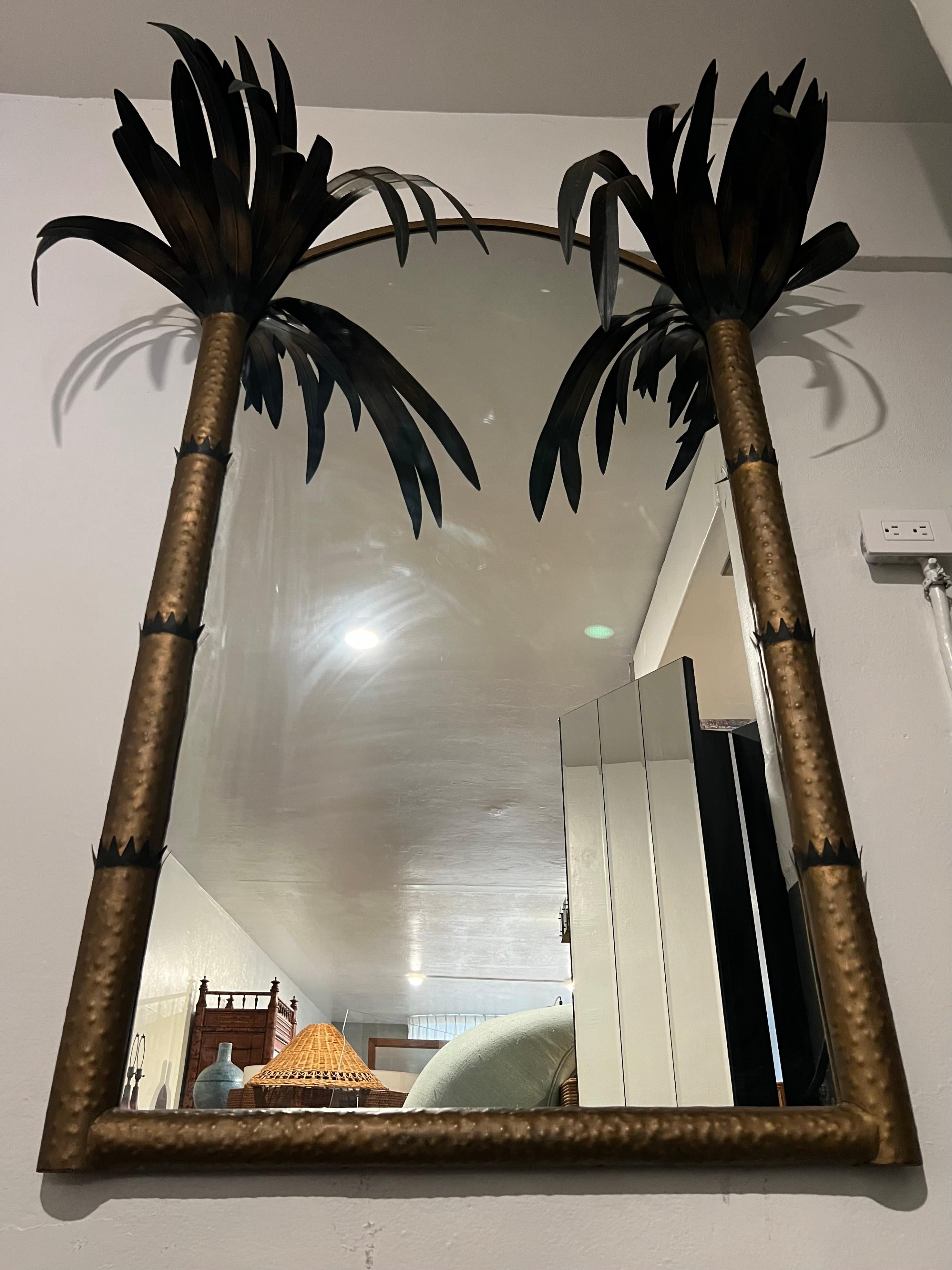 Dramatic metal tole style palm tree wall mirror. Heavy construction. Some spots of oxidation to the leaves (please refer to photos). Additional photos available upon request. Please note that the height, depth and width vary depending on the