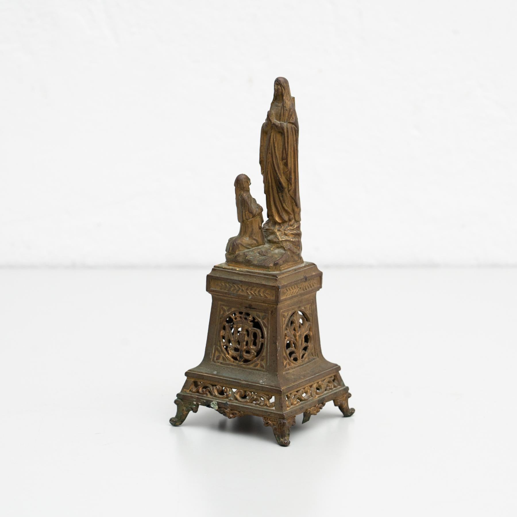 Spanish metallic virgin statue.    Made Spain, circa 1950.    In original condition, with minor wear consistent with age and use, preserving a beautiful patina.    Materials:  Metal.   