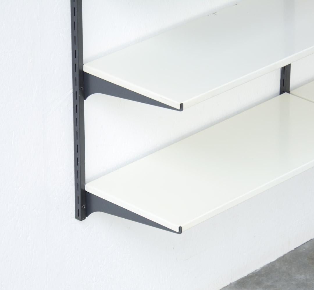 This special wall-mounted bookshelf was manufactured by Tomado in the 1960s.
It is a colorful modular piece.
We offer you a double wall-mounted unit with 11 shelves: four white shelves, four grey shelves and three red shelves. There are two