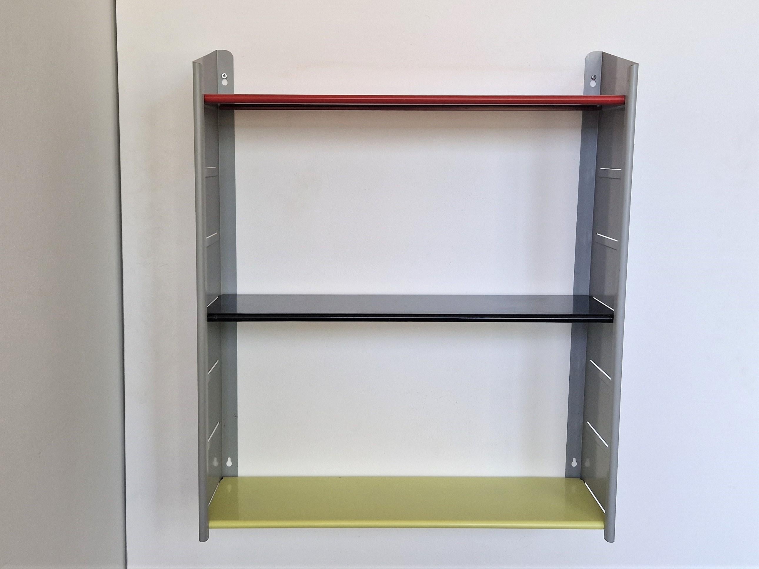 This stunning metal shelving unit was made by the Dutch manufacturer NVF in the 1960's. It is made out of 2 grey lacquered metal wall fixtures and 3 adjustable metal shelves in red, black and yellow. Considering age this unit is in a very good