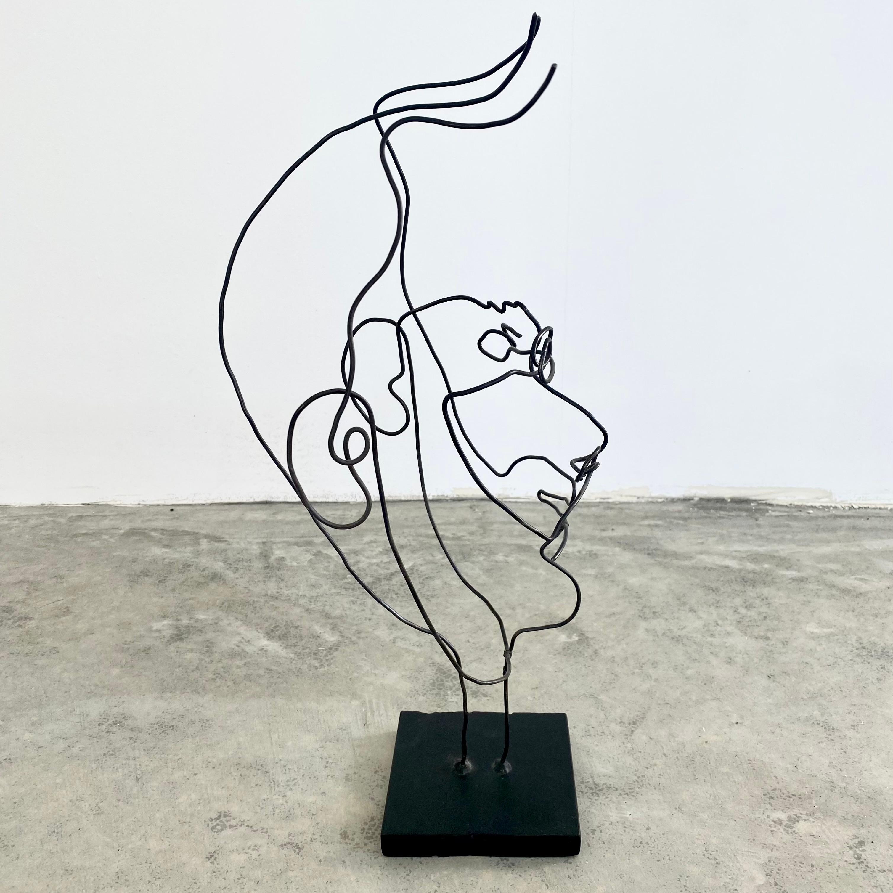 Stunning metal wire sculpture resembling a man's face. Thin metal wire is bent, molded and wrapped in order to give this piece its abstract structure and beautiful lines. Created by sculptor Mark Rane. Wire has movement to it when touched. Fun,