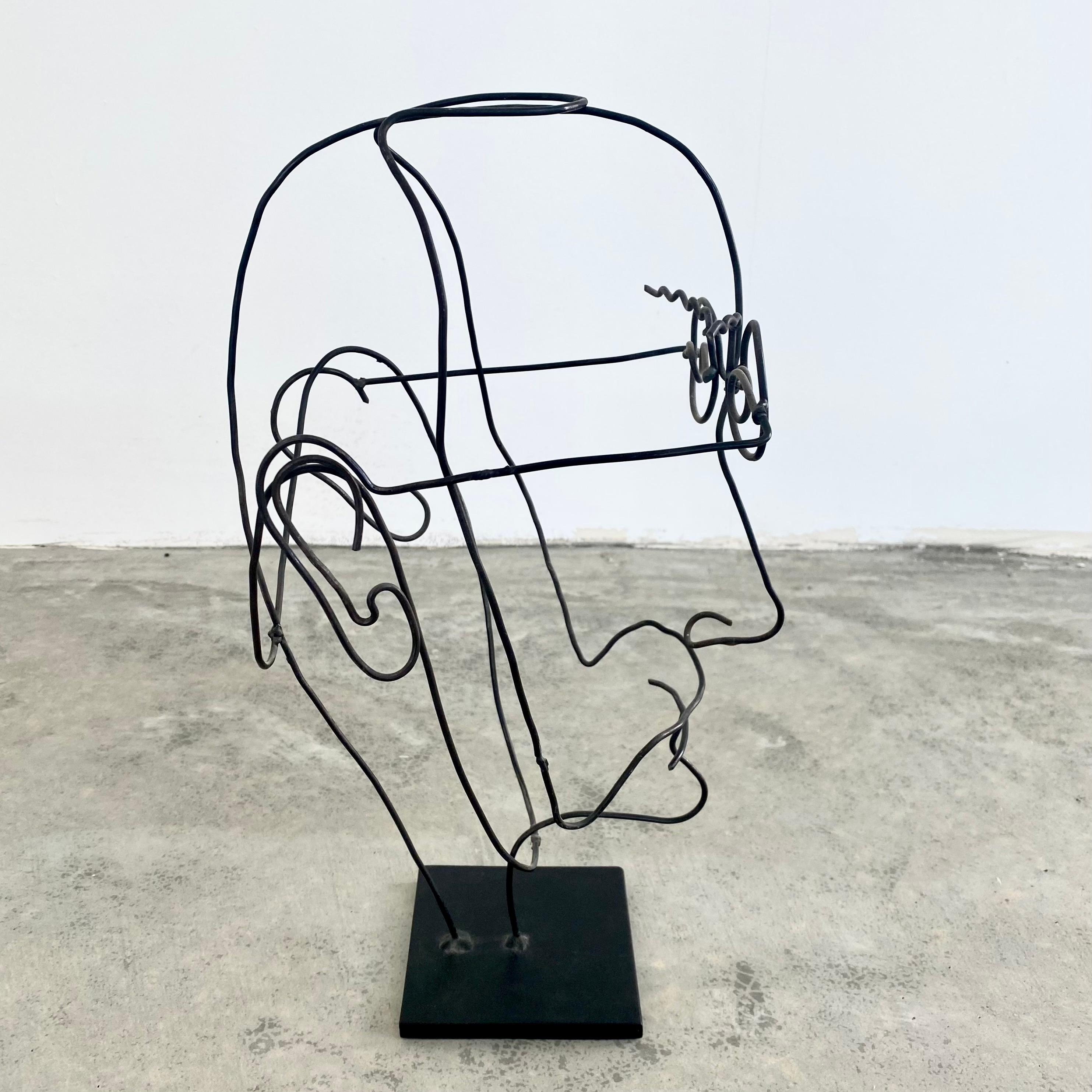 Stunning metal wire sculpture resembling a man's face. Thin metal wire is bent, molded and wrapped in order to give this piece its abstract structure and beautiful lines. Created by sculptor Mark Rane. Wire has movement to it when touched. Fun,