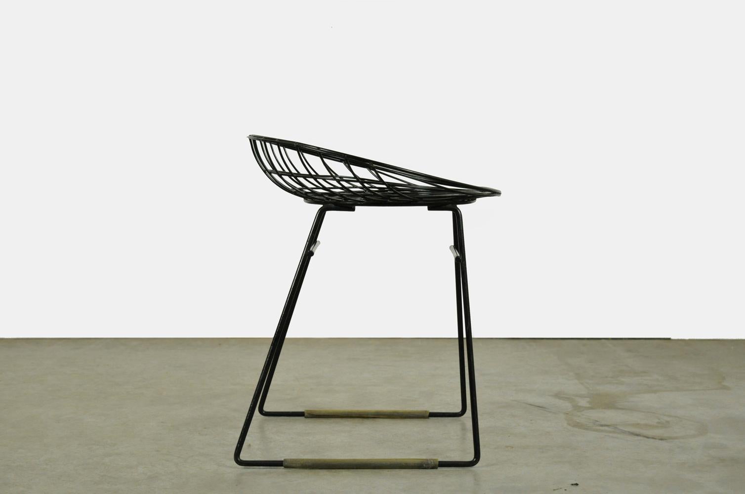 Metal wire stool KM05 designed by Cees Braakman and Adriaan Dekker for Pastoe, 1950s. The metal wires have a black plastic coating. The wire stool was designed in collaboration with Tomado in the 1950s. Original version with lower seat height. Two