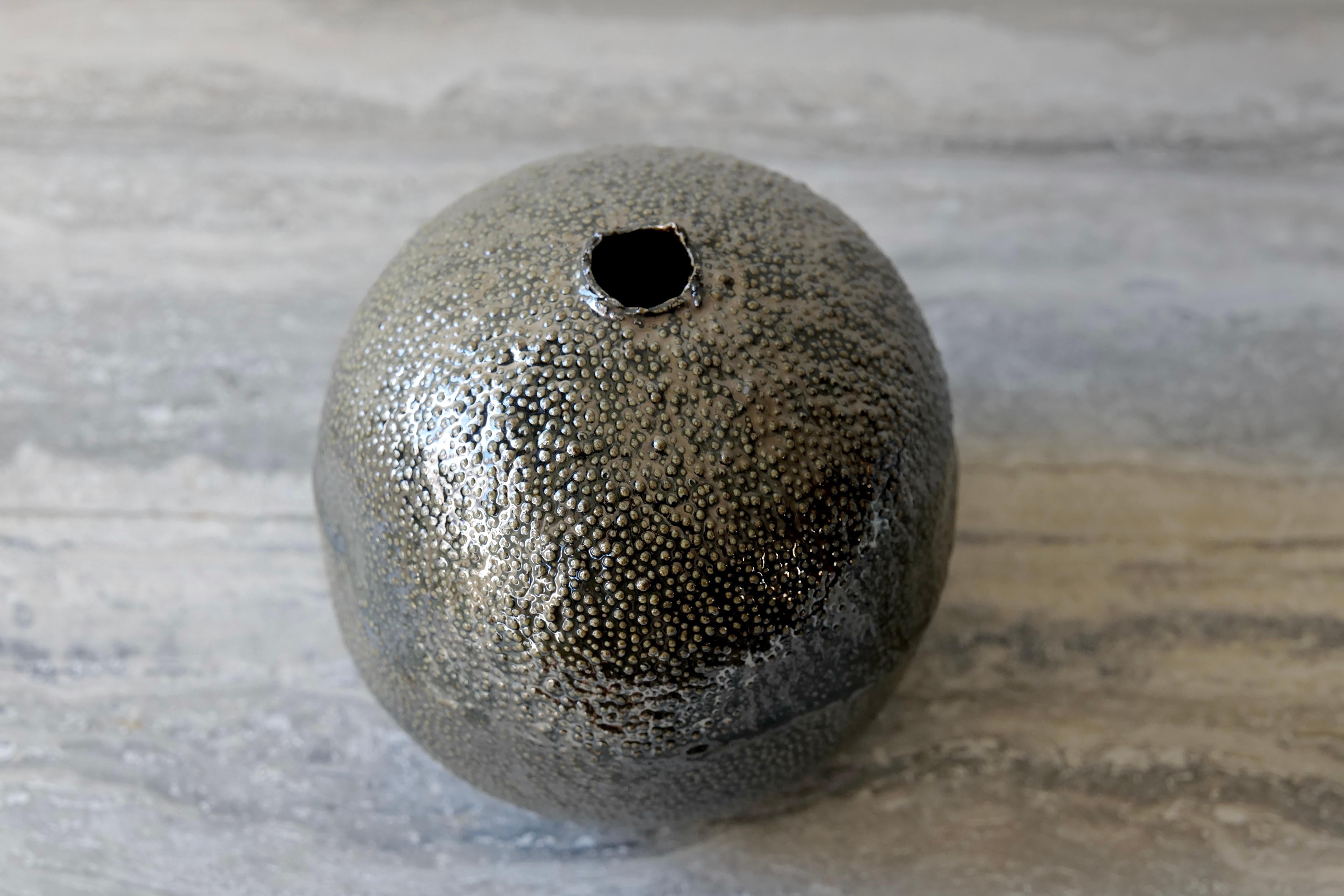 The Metallic Black Caviar Porcelain Vessel is a sculptural object that merges refinement with tactile intrigue. Slip cast in porcelain and meticulously finished with a micro-textured surface, it evokes the delicate patterning of caviar or stingray