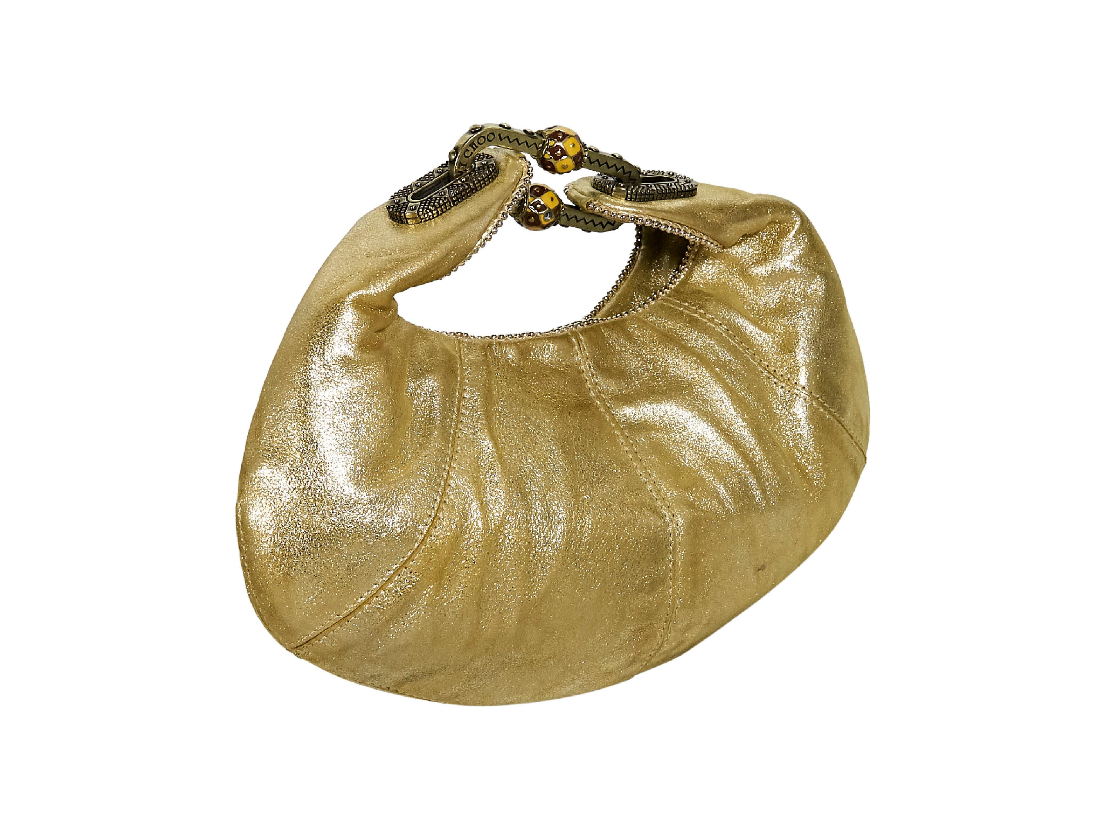 Product details:  Metallic gold leather hobo bag by Jimmy Choo.  Single shoulder strap.  Open top.  Lined interior.  Antiqued goldtone hardware.  10