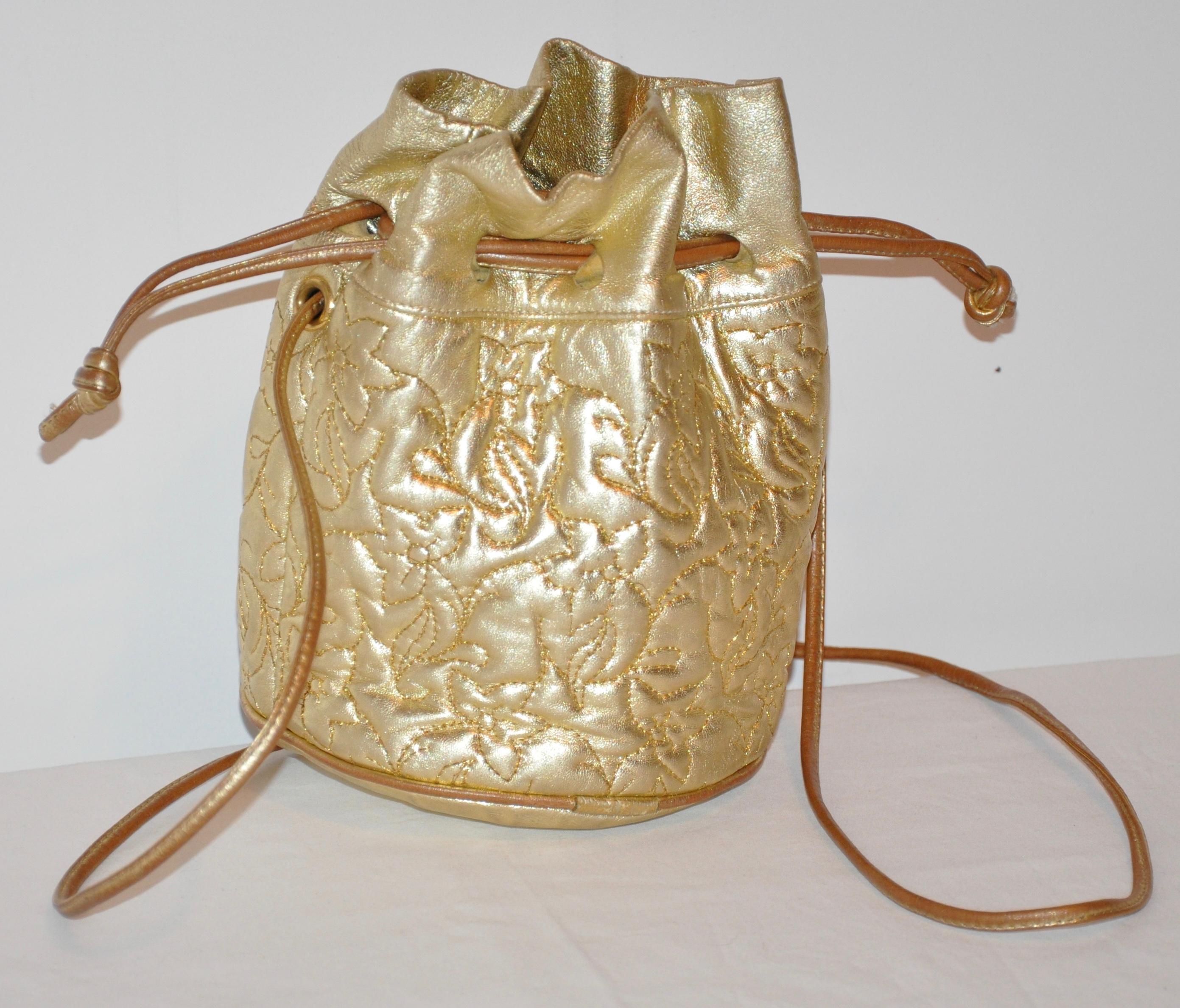     Elegant and whimsical metallic gold lambskin drawstring shoulder bag is detailed with floral-design topstitching. The interior is lined in black. Drawstring as well as the shoulder straps are of metallic lambskin. The bottom base measures 6