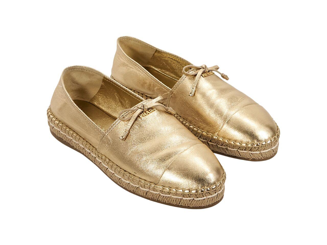 Product details:  Metallic gold leather flat espadrilles by Prada.  Round cap toe.  Slip-on style.  Label size IT 38.  
Condition: Pre-owned. Very good. 
Est. Retail $ 795.00