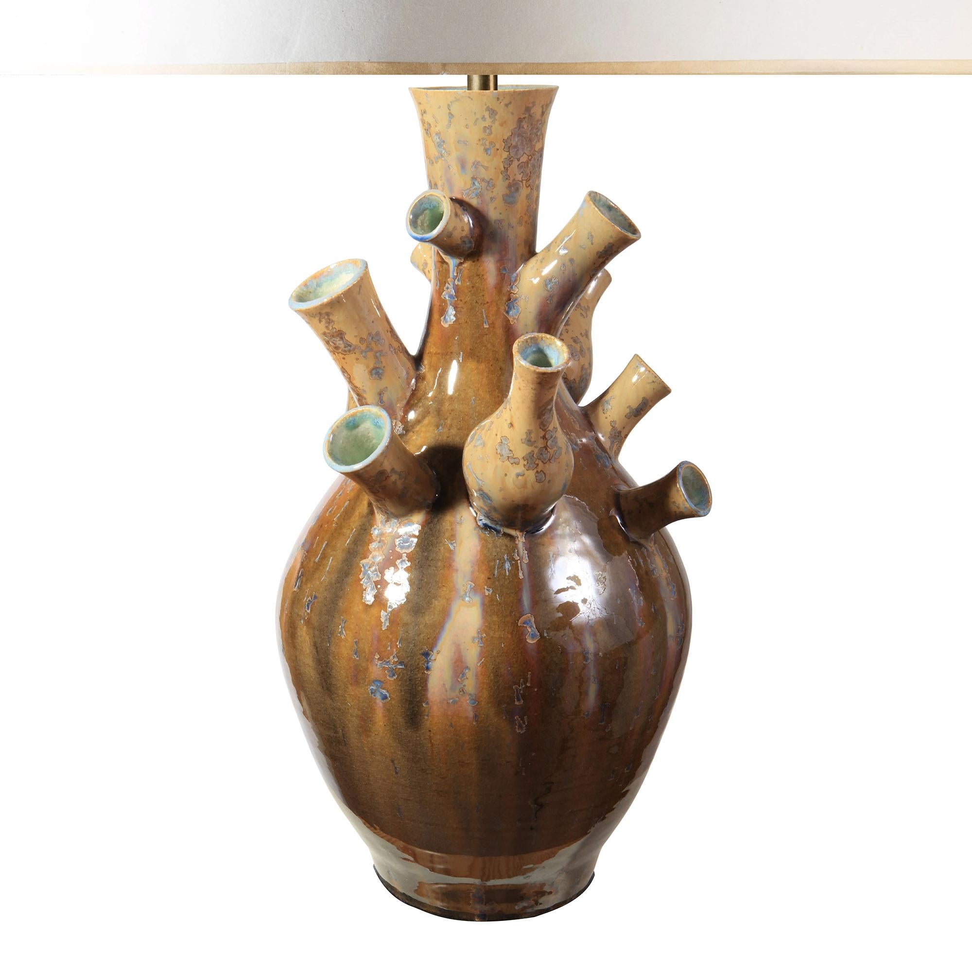 Una excepcional y escultural lámpara de sobremesa que presenta un dinámico grupo de cuellos que se elevan desde una base de porcelana redondeada. Cada extensión en forma de surtidor da a la forma una sensación de movimiento orgánico, evocando ramas