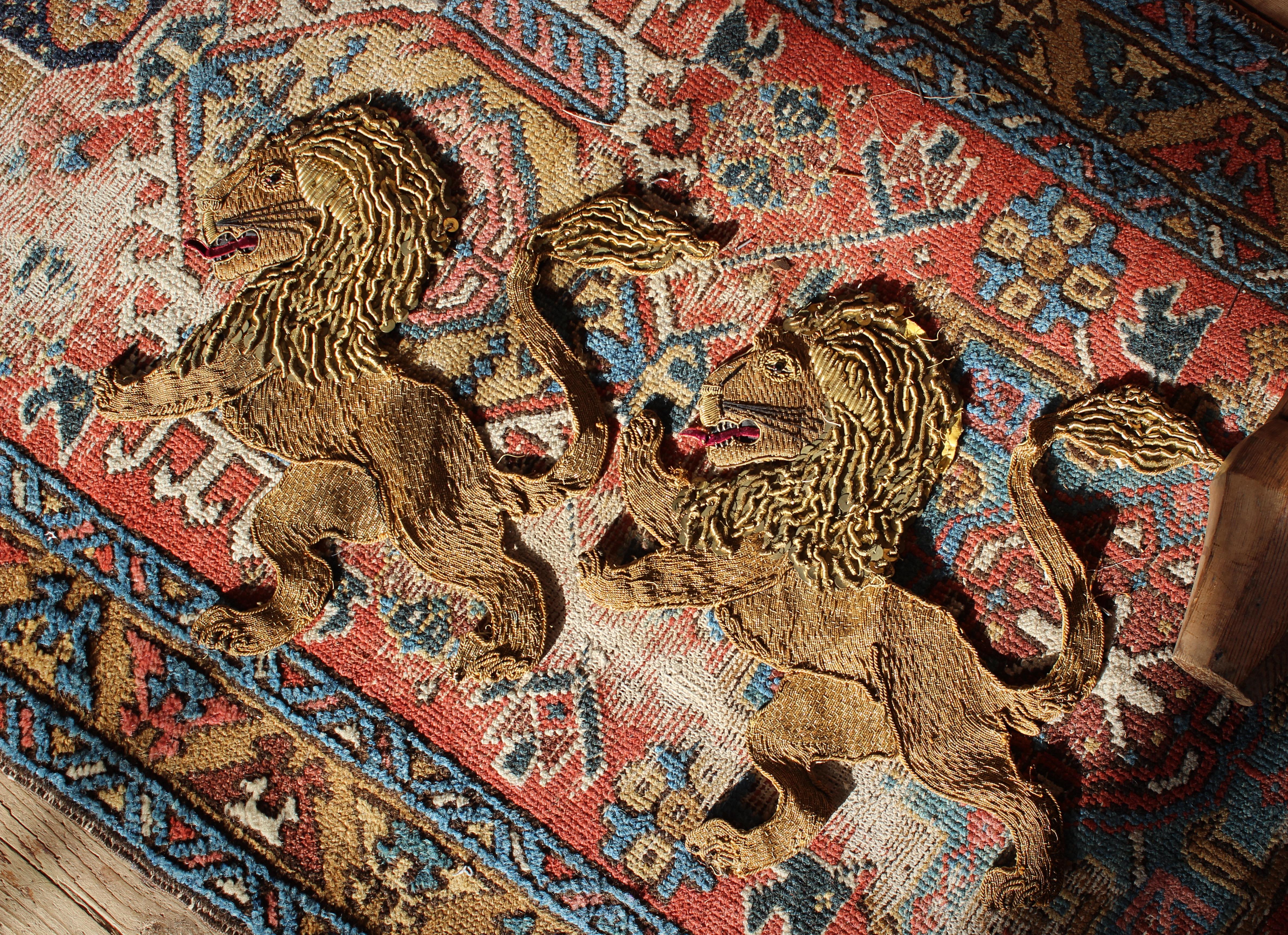 A fine hand made pair of appliqués, metal threaded, with sequins, velvet highlights and beaded eyes.

Depicting a pair of rampant lions, possibly previously part of a military banner or the like.

Second quarter of the 20th century in age 

38cm in