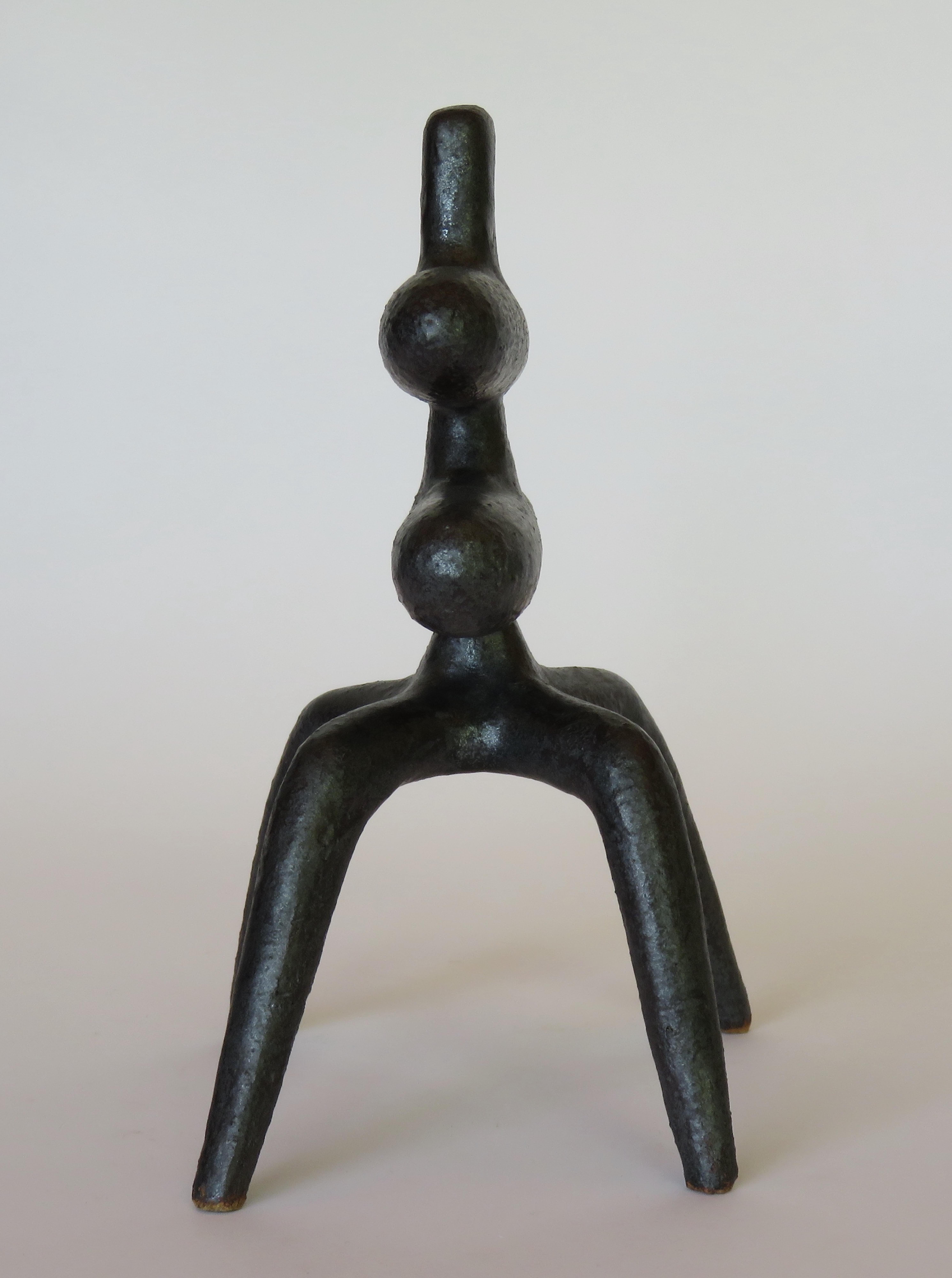 Cette sculpture en céramique faite à la main, de couleur gris argenté métallique, évoque une créature fière qui marche et observe. Un TOTEM moderne, abstrait avec une tête inclinée sur deux barres centrales, en équilibre sur 4 pieds.   Cuite à haute