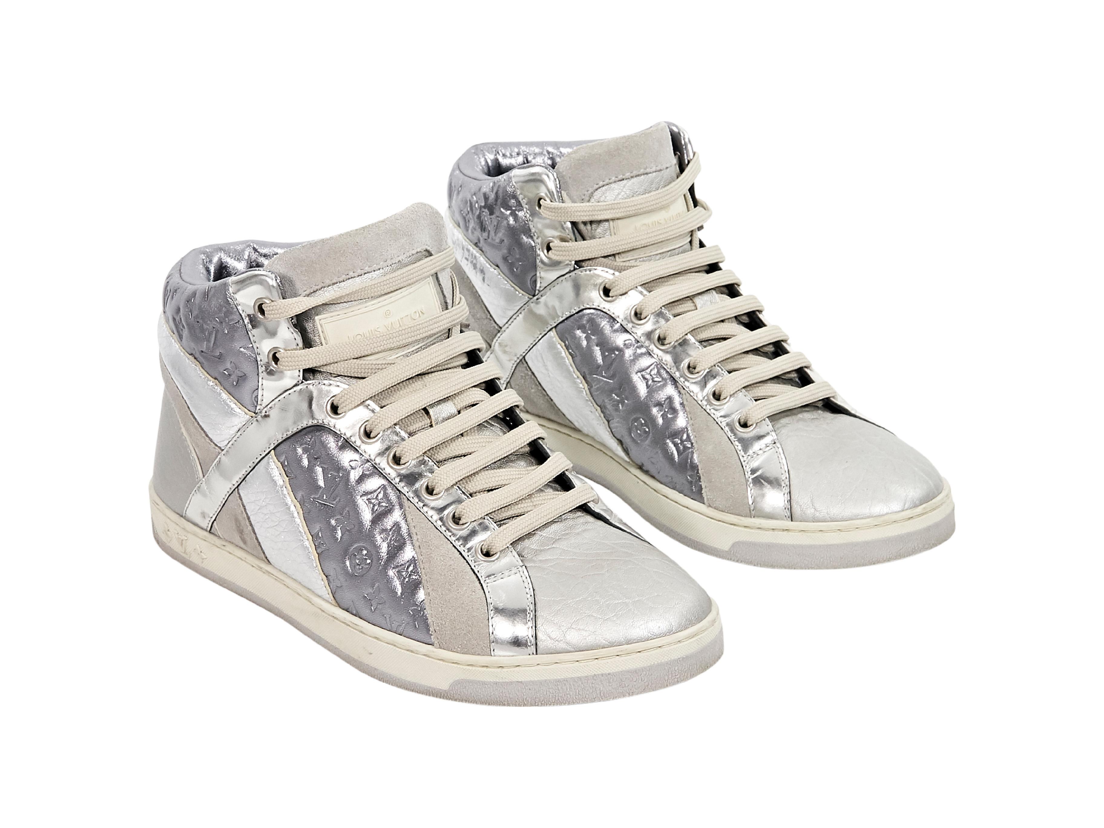Product details:  Metallic silver high-top sneakers by Louis Vuitton.  Accented with monogram embossing.  Lace-up closure.  Round toe.  
Condition: Pre-owned. Very good.
Est. Retail $ 895.00