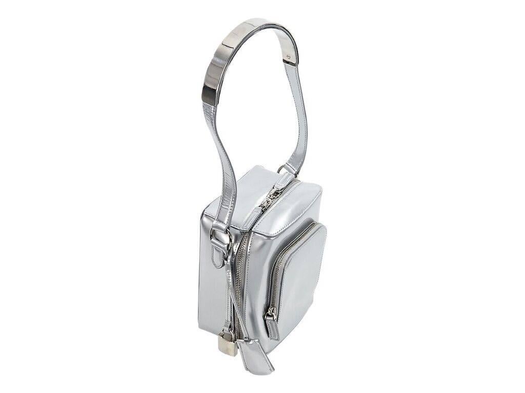 Product details:  Metallic silver leather mini box bag by Salvatore Ferragamo.  Single shoulder strap with hanging lock and key.  Zip-around closure.  Lined interior with inner slide pocket.  Front exterior zip pocket.  Protective metal feet. 