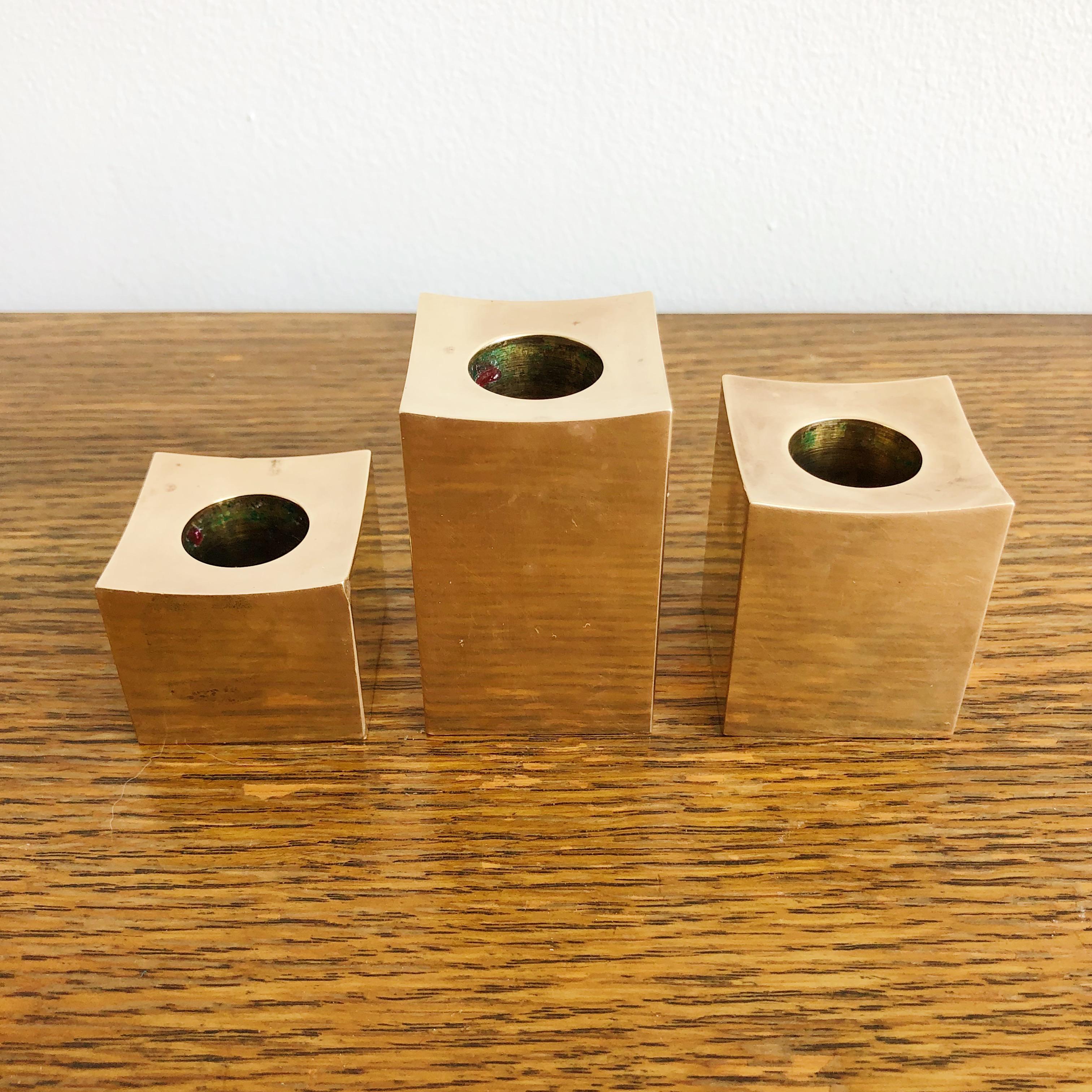 Set of three solid bronze candle holders signed on base Metallslojden Gusum 1984, Made in Sweden. Ranging in heights from 1.25