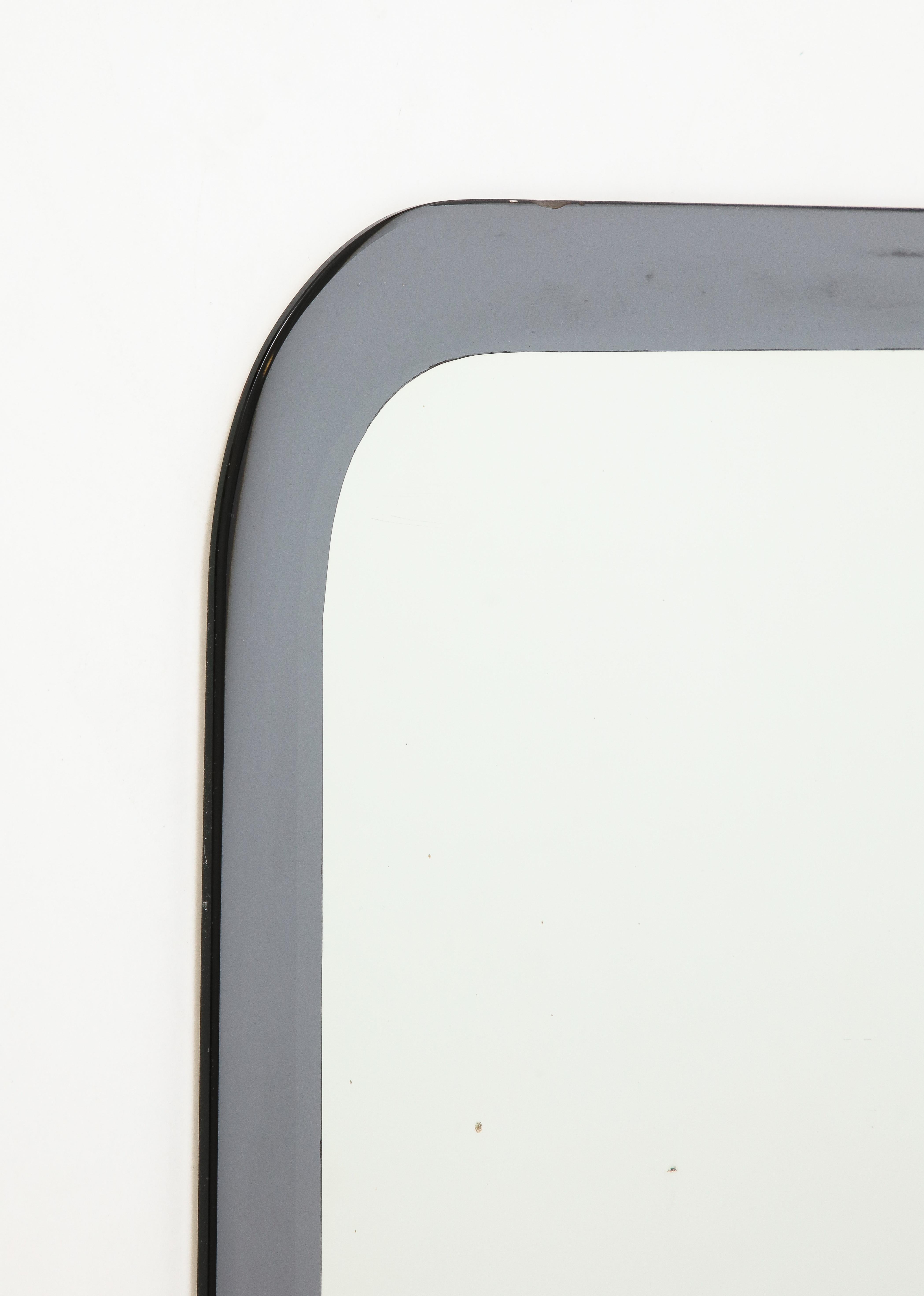 An Italian all glass shaped mirror with silver/grey border made by Metalvetro Galvorame, dated 1967.  The mirror is very well-made and heavy. It comes with its original label signed 