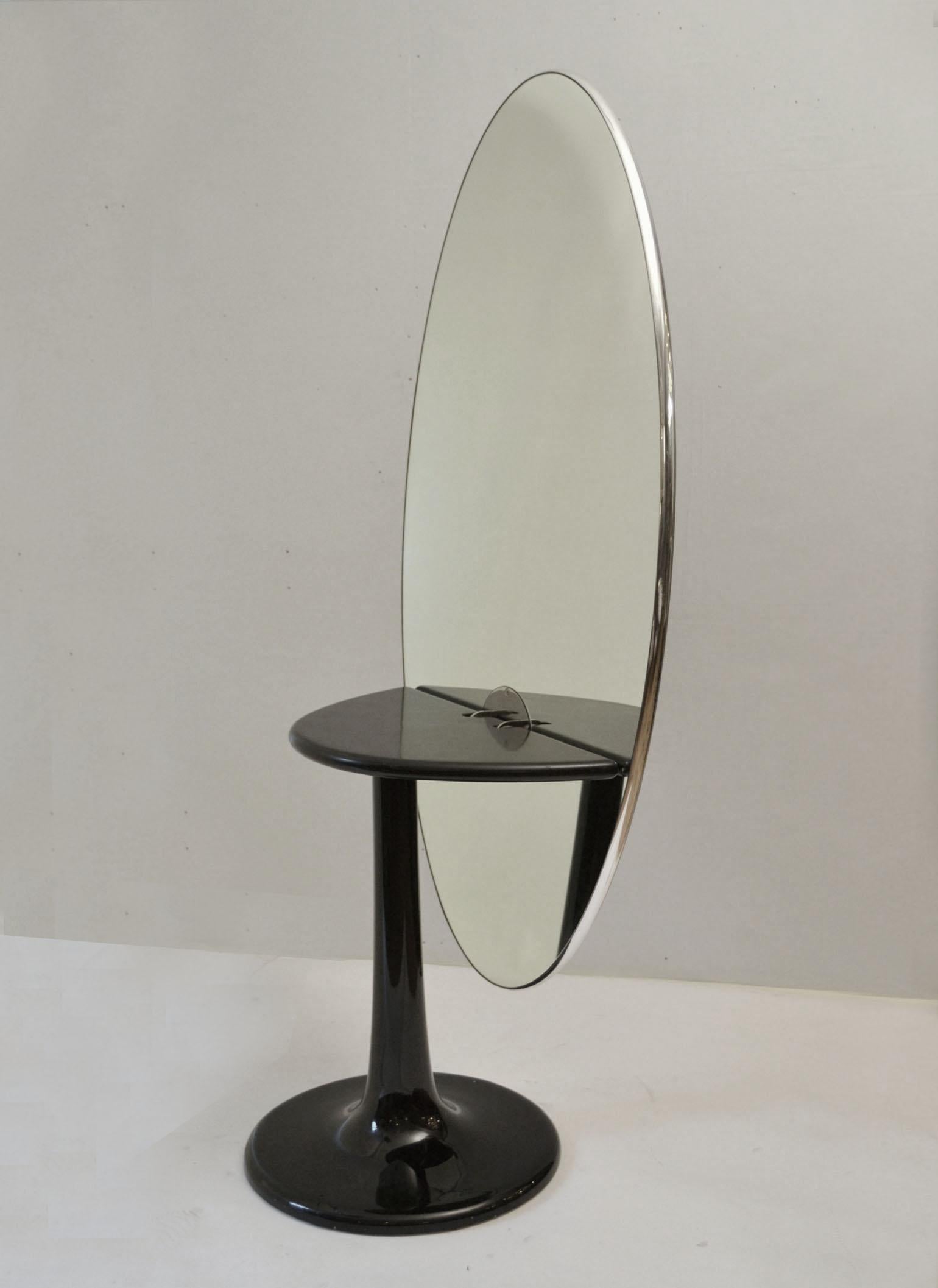 Extraordinary Mid-Century Modern sculptural oval table with a surprise; when the top is lifted up by a simple hand movement it reveals a vanity mirror. The black glass table top trimmed with a chromed edge that stands off center from its elliptical
