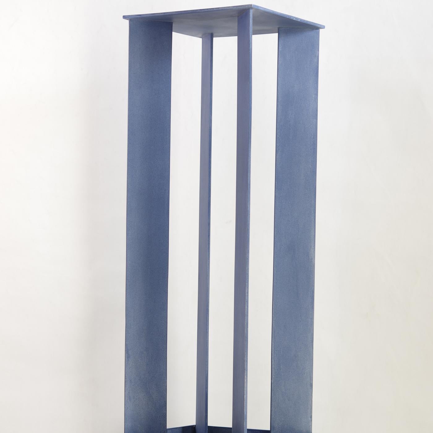 A tribute to Giorgio De Chirico, this iron sculpture is part of the Torri series (towers in English) and features a sturdy square base supporting an intriguing upright construction. The structure has four flat panels in the corners of the base