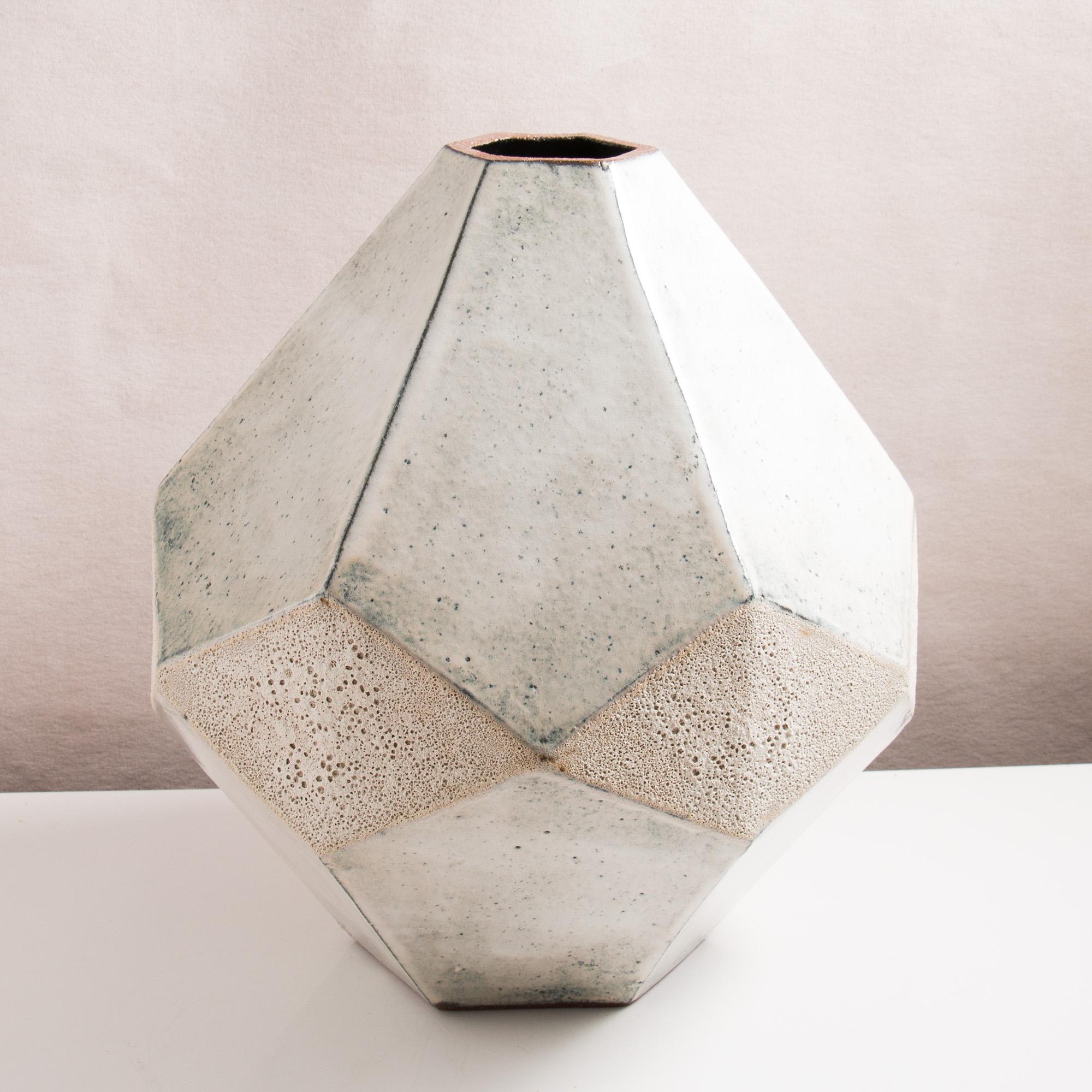 This large one-of-a-kind ceramic vase combines clean geometric lines with the warmth and individuality inherent in handmade work. It was assembled from flat sheets of a rich red-brown stoneware, into a complex geometric shape that feels both natural