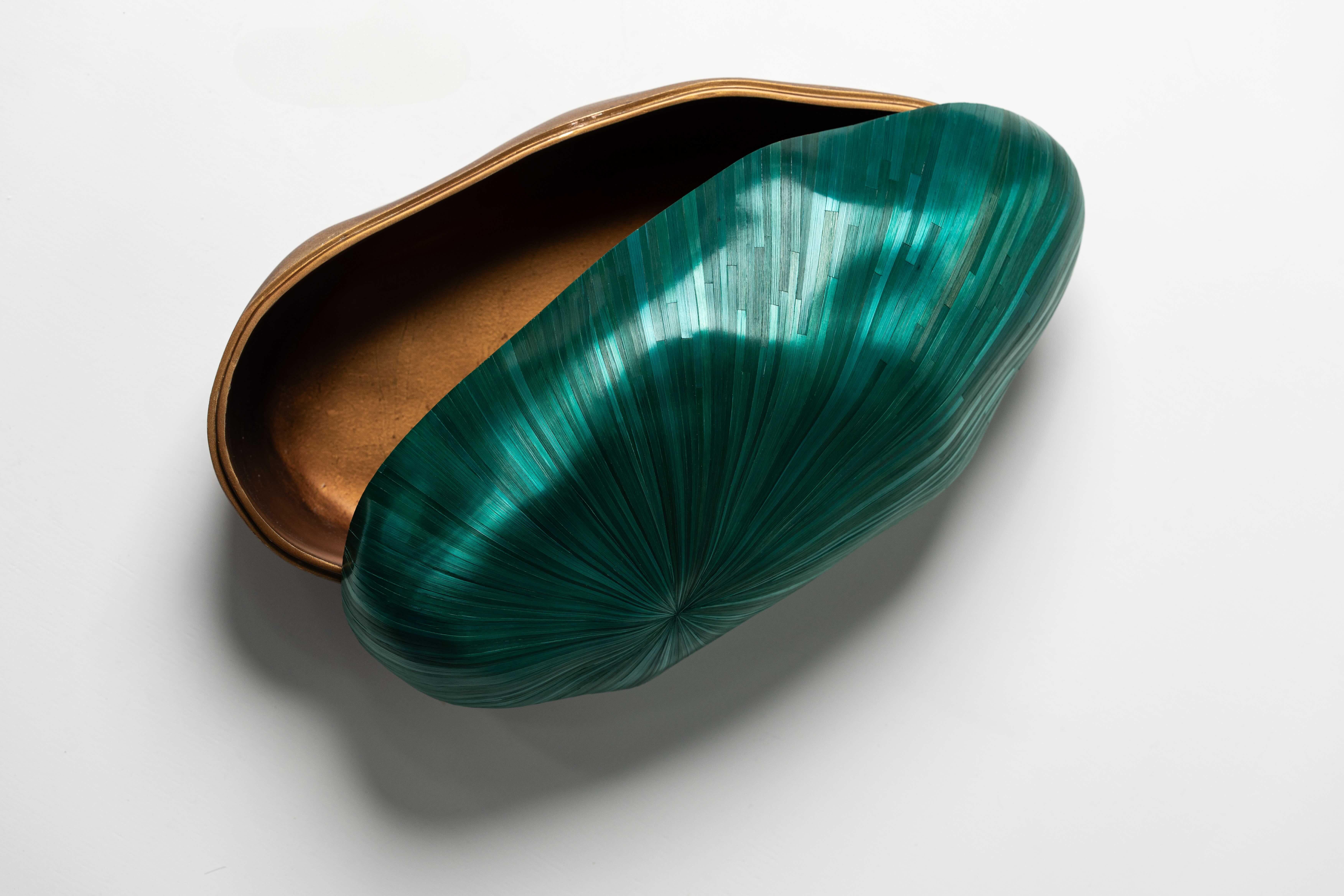 A sculptural box with a radiant green straw marquetry lid and gold foil body. A bold piece that brings celestial charm to your space. The finishes, colours, size can be customised according to specifications. 

Scarlet Splendour’s straw marquetry
