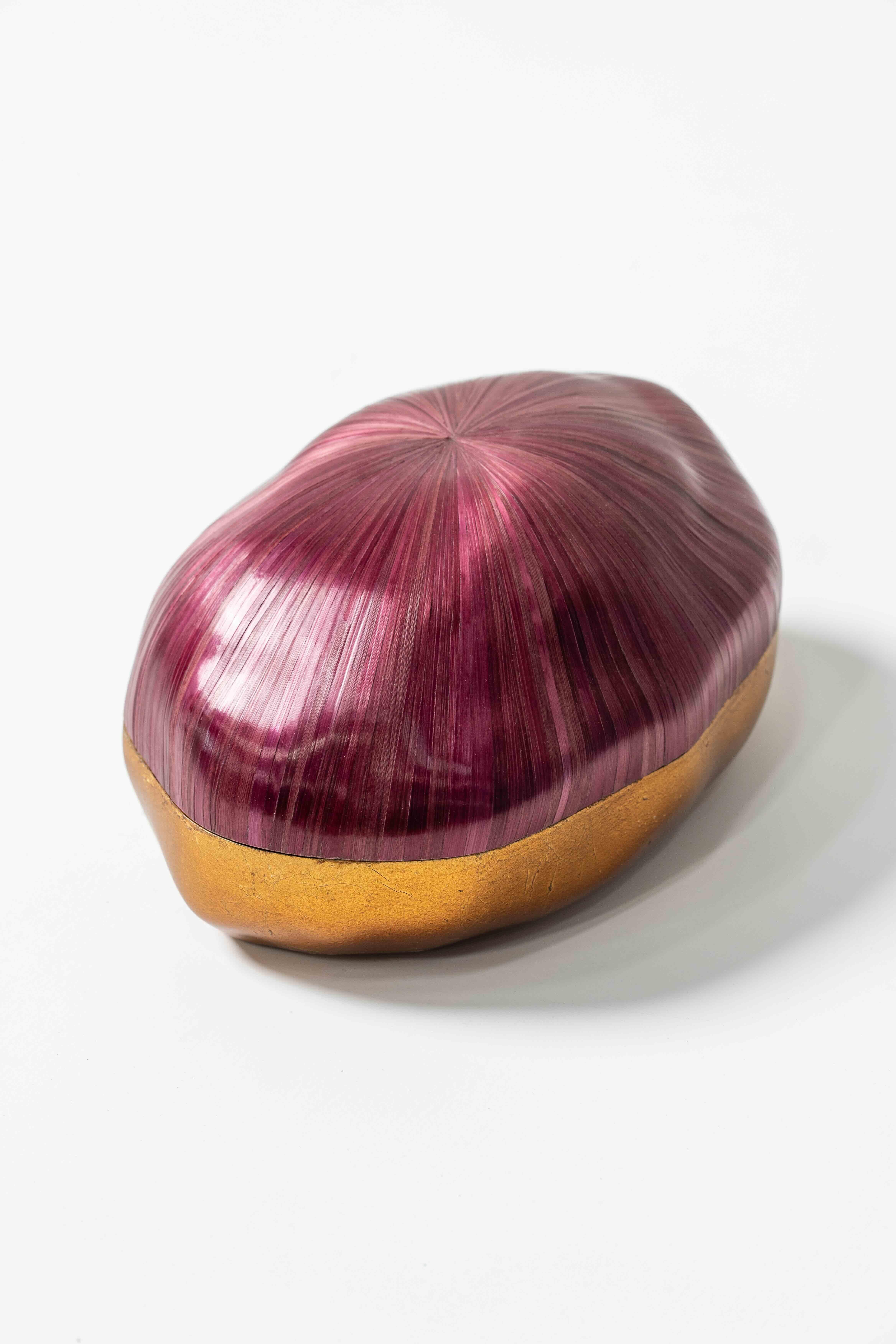 A gleaming maroon straw marquetry box with a gold foiled base. Compact, refined and irresistibly cosmic in its allure. The finishes, colours, size can be customised according to specifications. 

Finest quality straw sourced from France and