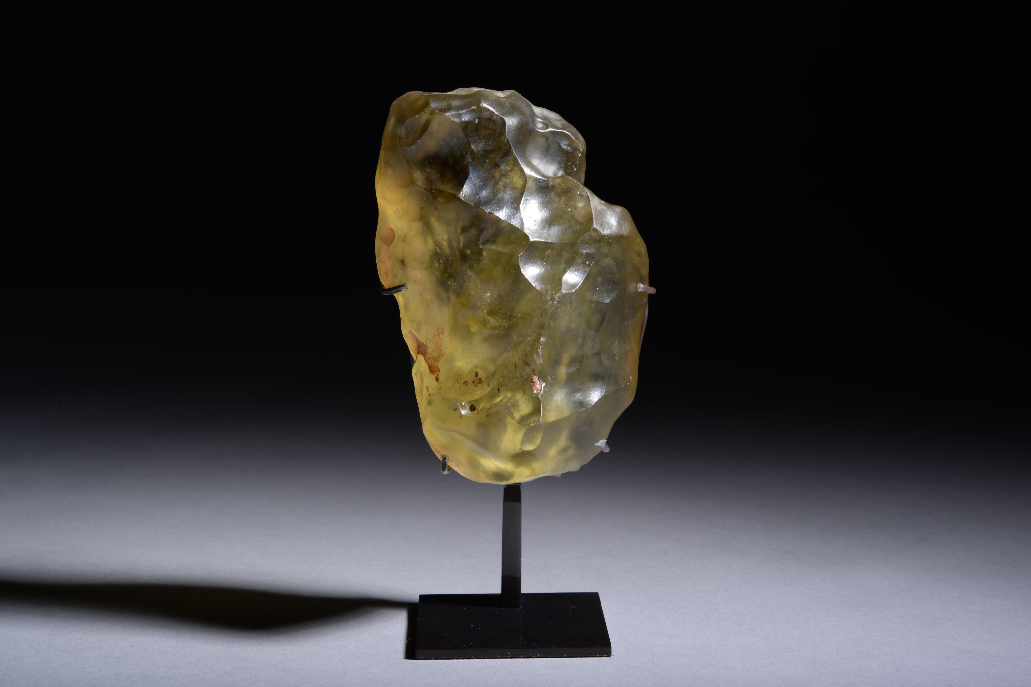 Libyan Desert Glass
Circa 29 Million y/o
Height: 9.5 cm

A beautiful, tactile piece of yellow glass, found between the high crested dunes of the Libyan Desert.  Libyan Desert Glass (LDG) long remained a mystery to the scientific community, with some