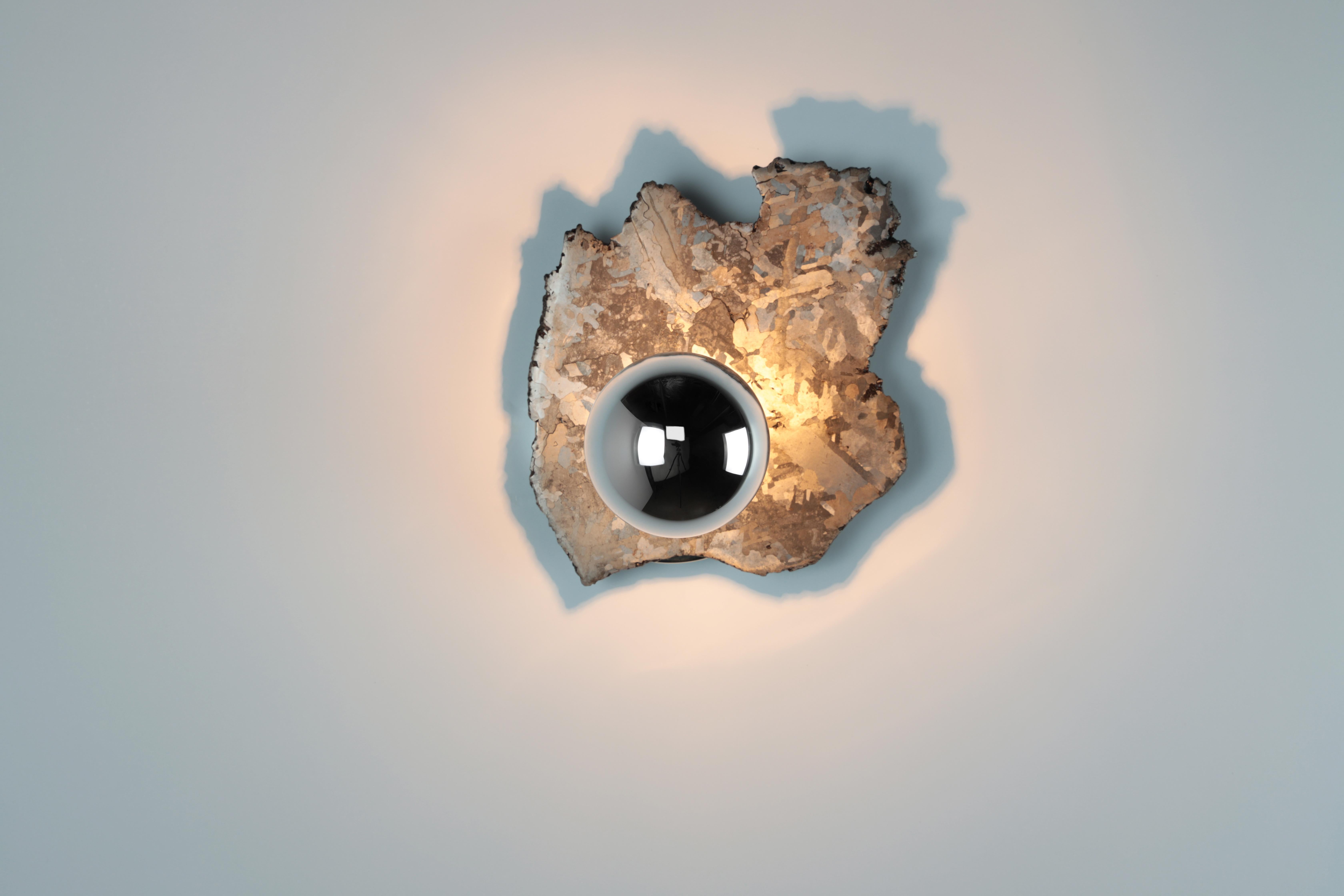 Bring a little piece of outer space into your interior space with this pair of galactic Meteorite sconces.
A large meteorite dated 5500 years old was cross sectioned and polished. The fixture comes with a pair of half chromed medium socket halogen