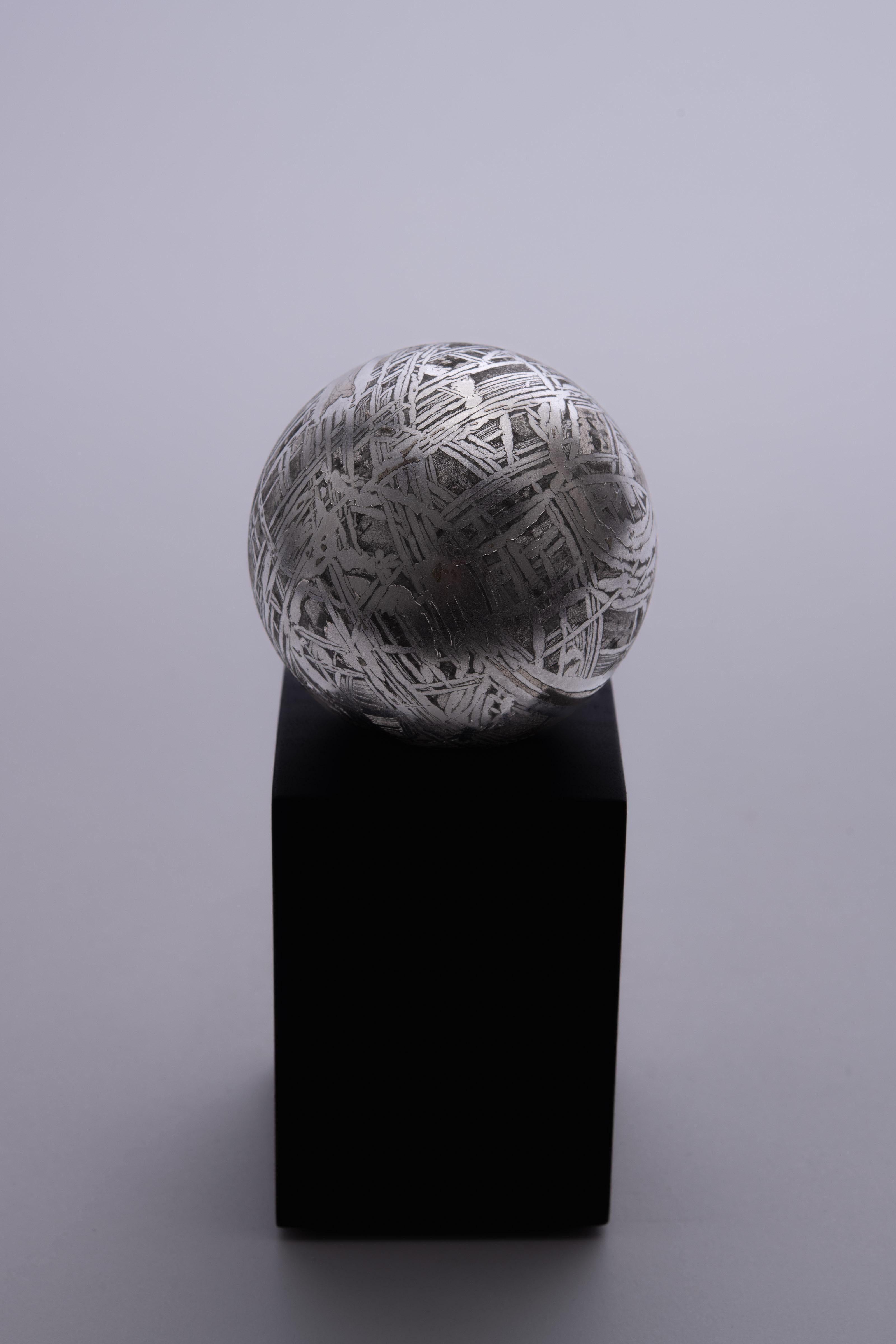 A magnificent meteorite sphere, cut from the famous Aletai meteorite and polished to reveal the shimmering iron-nickel matrix and the beautiful crystalline Widmanstätten pattern — a striking, criss-cross structure unique to extraterrestrial