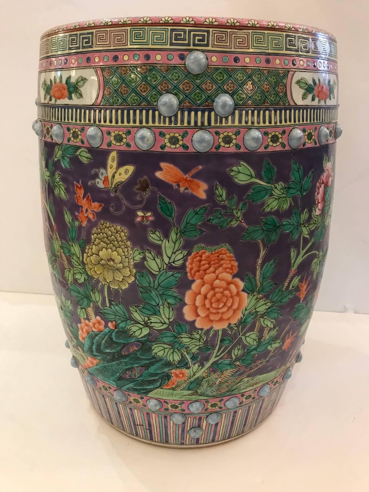 Absolutely gorgeous round Chinese garden seat with meticulous decoration having flowers, butterflies and such, in a dreamy color palette of lavender, greens, orange and pink. Makes a scrumptious occasional table.  
 