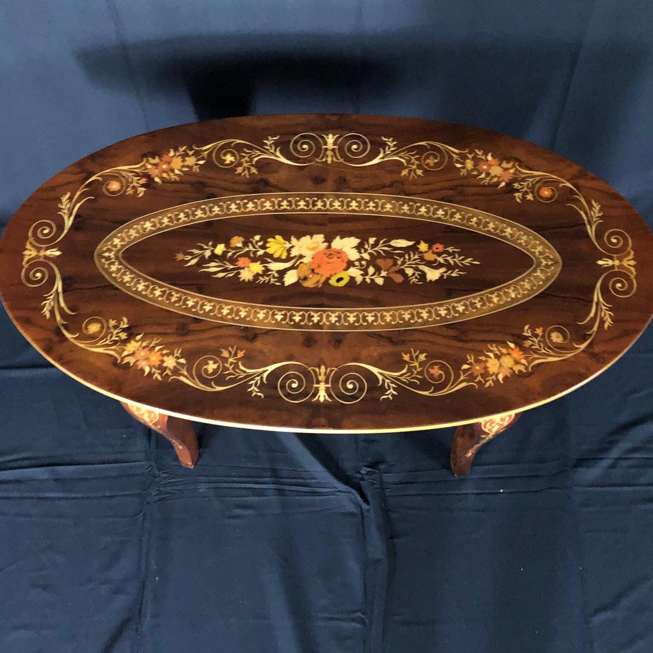 Table basse ovale italienne avec une exquise marqueterie florale à volutes de différents bois, même sur les élégants pieds subtilement courbés.
 #5092.