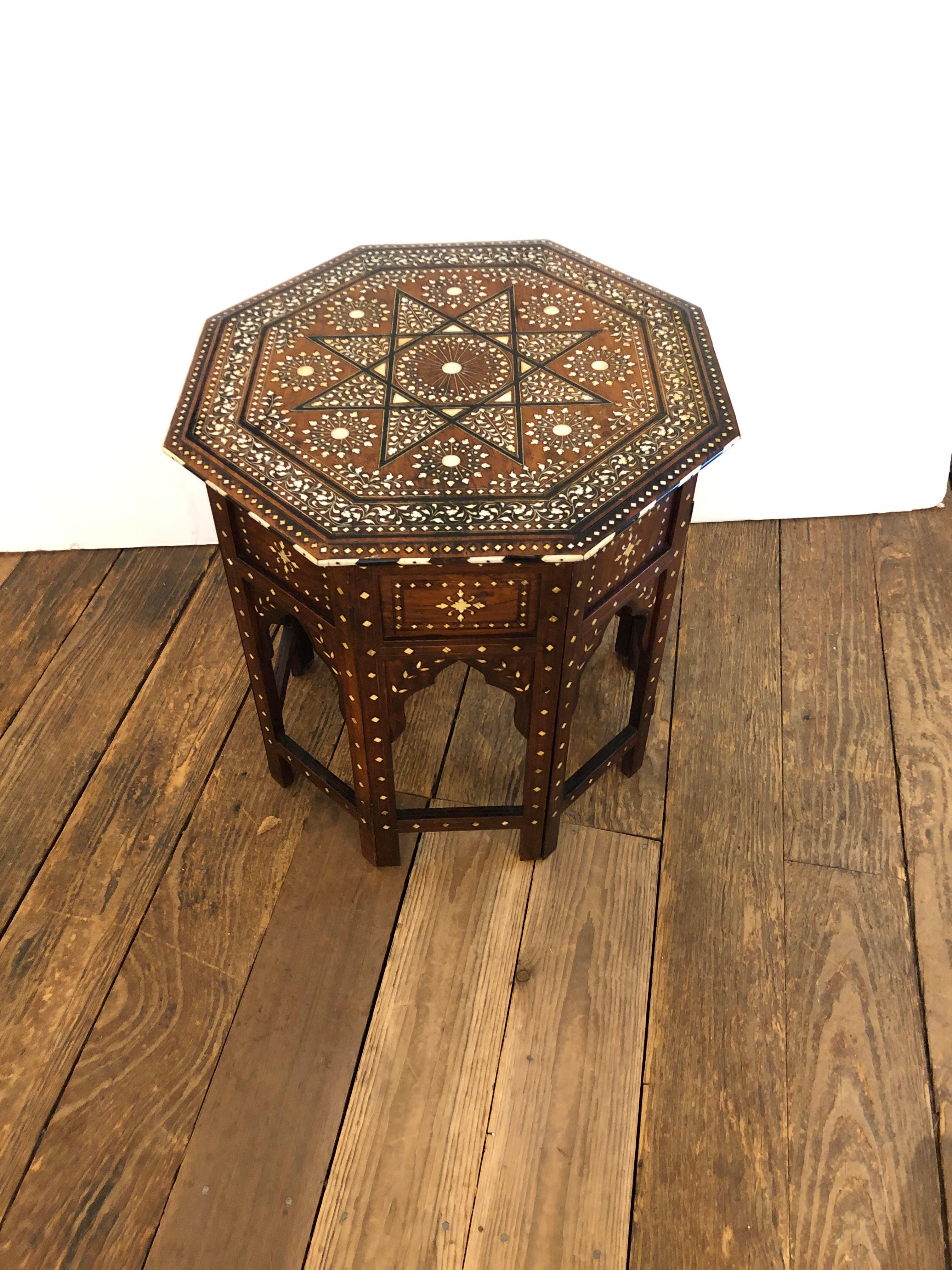 A particularly ornate and beautiful Moroccan or Anglo-Indian side table having octagonal top with superb mother of pearl inlay and central star. The base accordians open and closed with classic Moorish arch motife and continuation of meticulous
