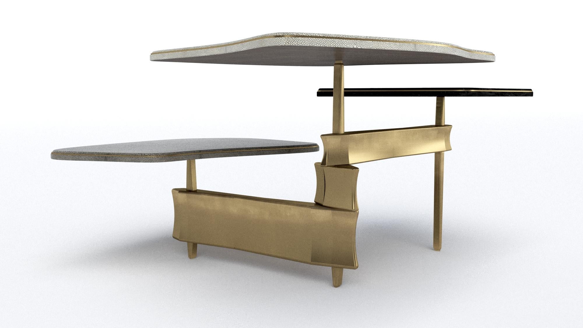 The Metropolis 3-top coffee table by Kifu Paris is a dramatic and sculptural design that demonstrates the incredible and signature artisanale work from her Augousti genes. The bronze-patina brass base of the coffee table is conceptually inspired by