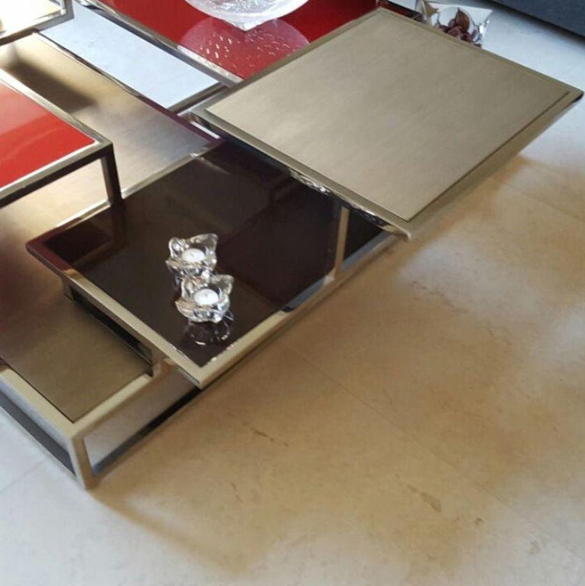 A coffee table with tops disposed at different heights, evocative of the mismatched buildings of a city.
It is made of polished stainless steel structure, tops and shelves in patinated silver and gold leaf, greyish sycamore, 100% gloss, and 2 red