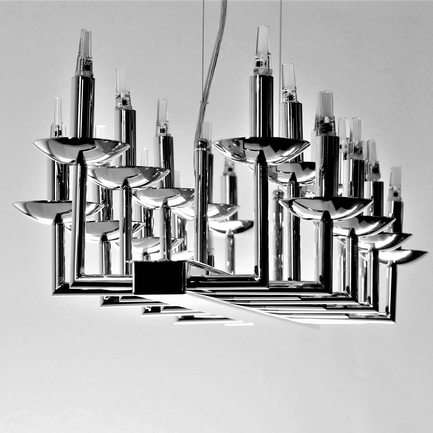 The 2021 new version of the modern chandelier METROPOLITAN by Luigi Aiardo features small L-shaped arms with a sleek and minimal design attached to rectangular modules. METROPOLITAN is one of the Italian brand Aiardini's bestsellers for luxury