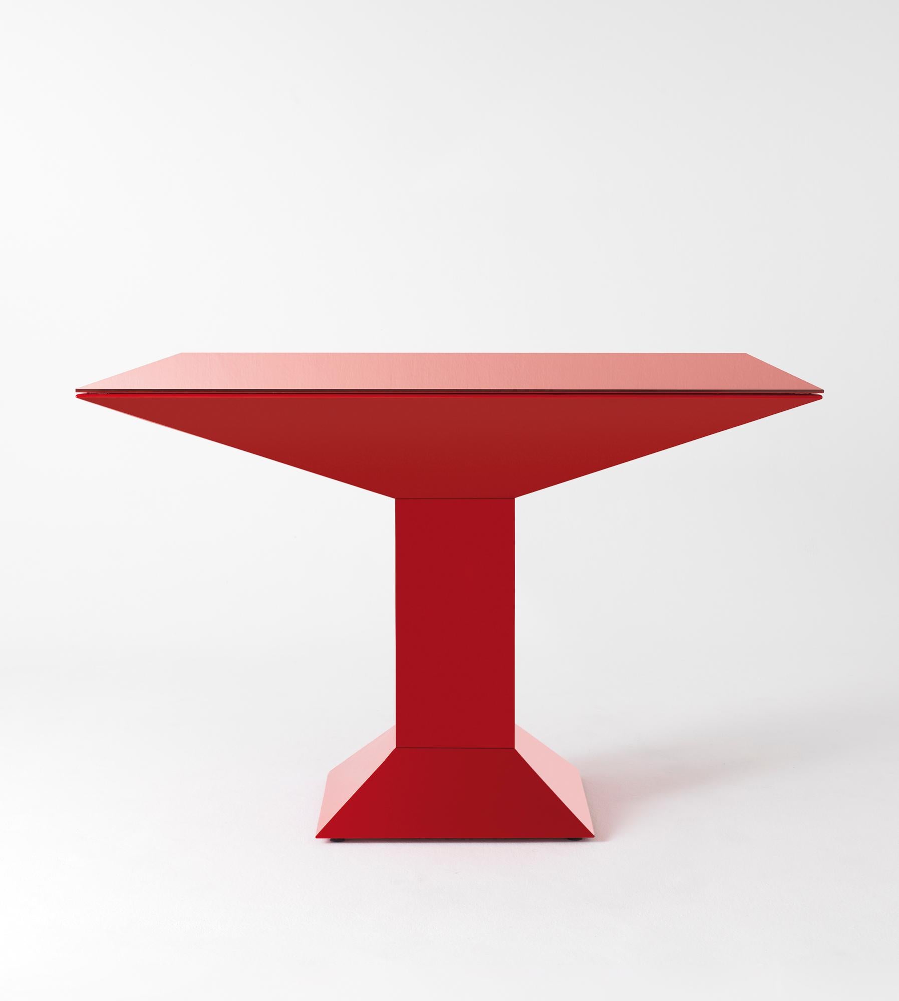 Table à manger Mettsass, Ettore Sottsass
Dimensions : 110 x 110 x 73 H cm
MATERIAUX : acier, verre

La structure est constituée de feuilles d'acier plates peintes en rouge. Le verre du dessus est peint dans la même couleur que la