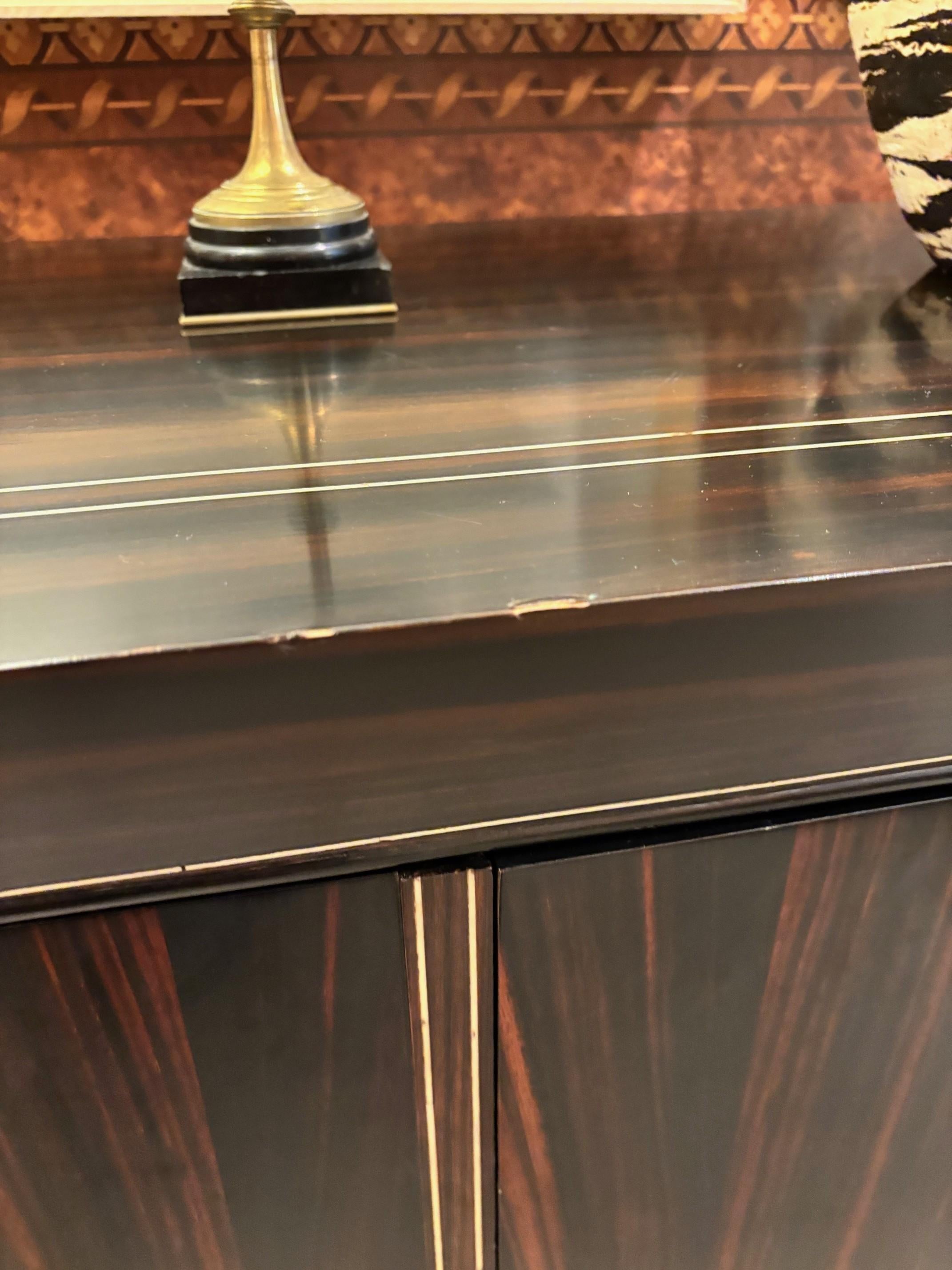 Buffet in stile contemporaneo con tre ante rivestite in ebano di Amara e accessoriate con osso sartoriale e ottone anticato. 

