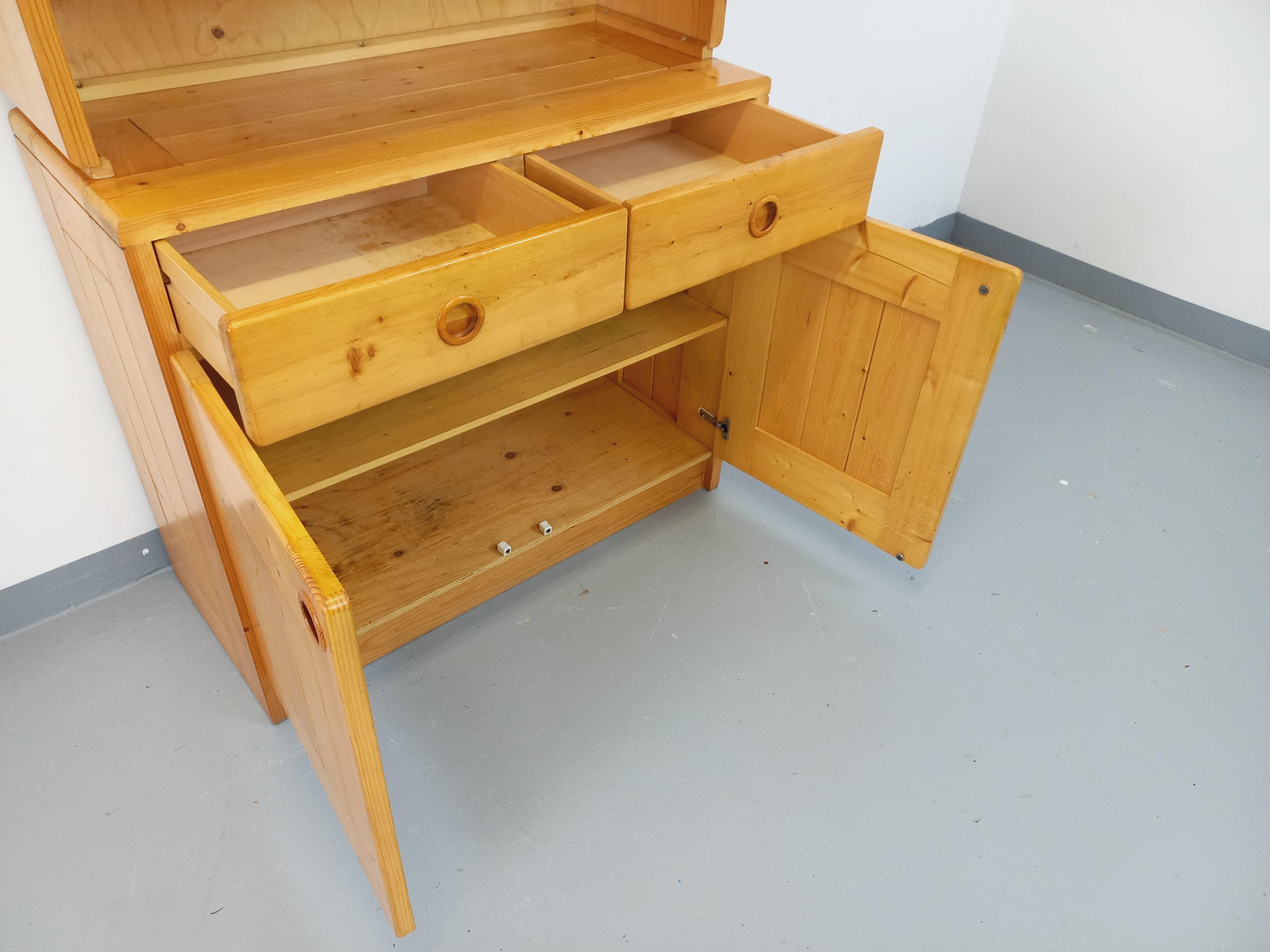 Meuble de rangement vintage type armoire vaisselier des années 60 70, en pin, de Charlotte Perriand pour Les Arcs, 4 tiroirs coulissants et 4 portes avec 2 étagères intérieures, bon état général avec des signes du temps qui passe.
Réf 240