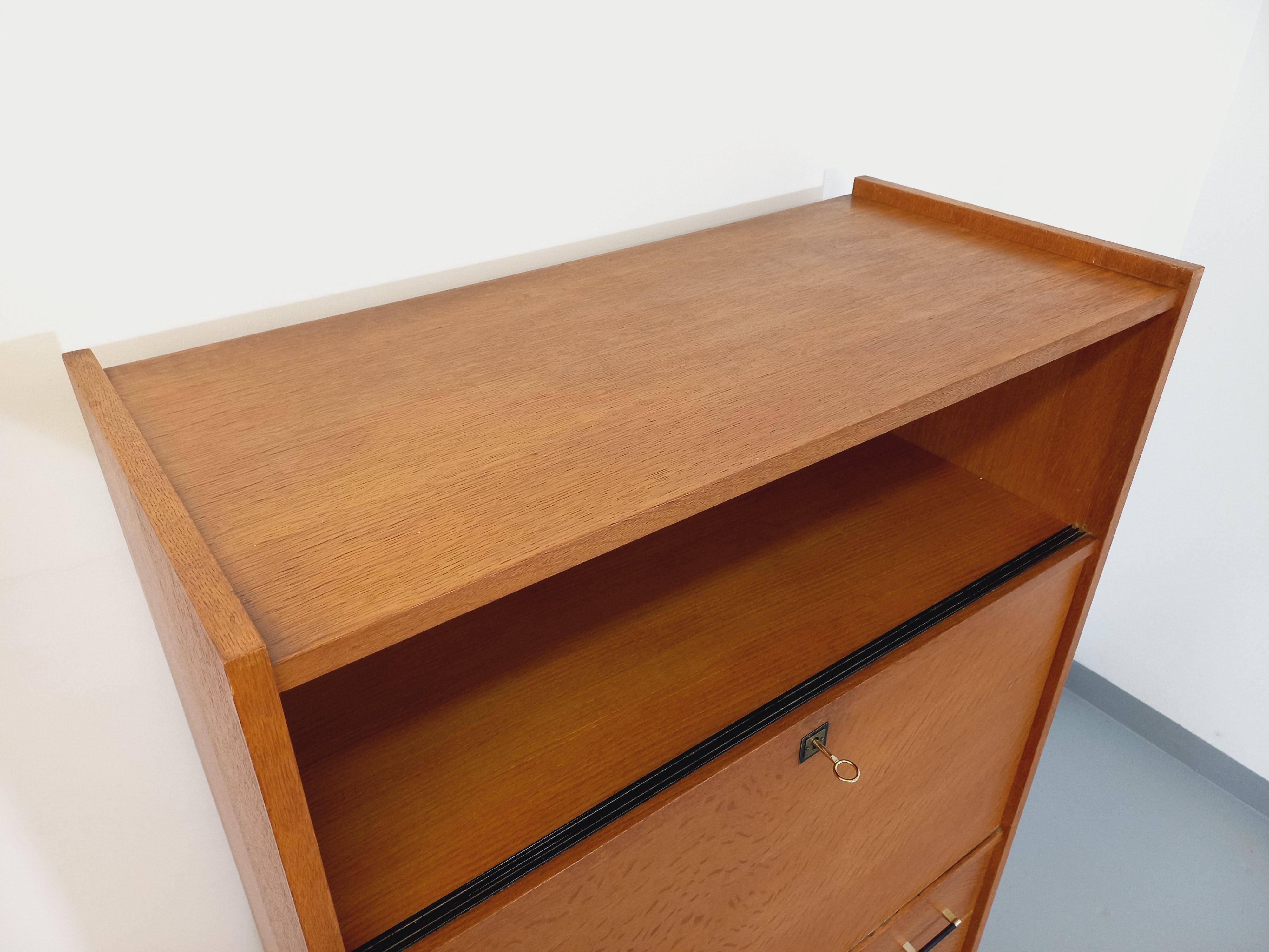 Meuble de rangement secrétaire vintage des années 50 60, en bois clair, pieds compas en métal noir et boule laiton, 1 niche ouverte, 1 partie secrétaire/bureau fermant à clé avec 1 étagère intérieure, 3 tiroirs en partie basse avec poignées noires