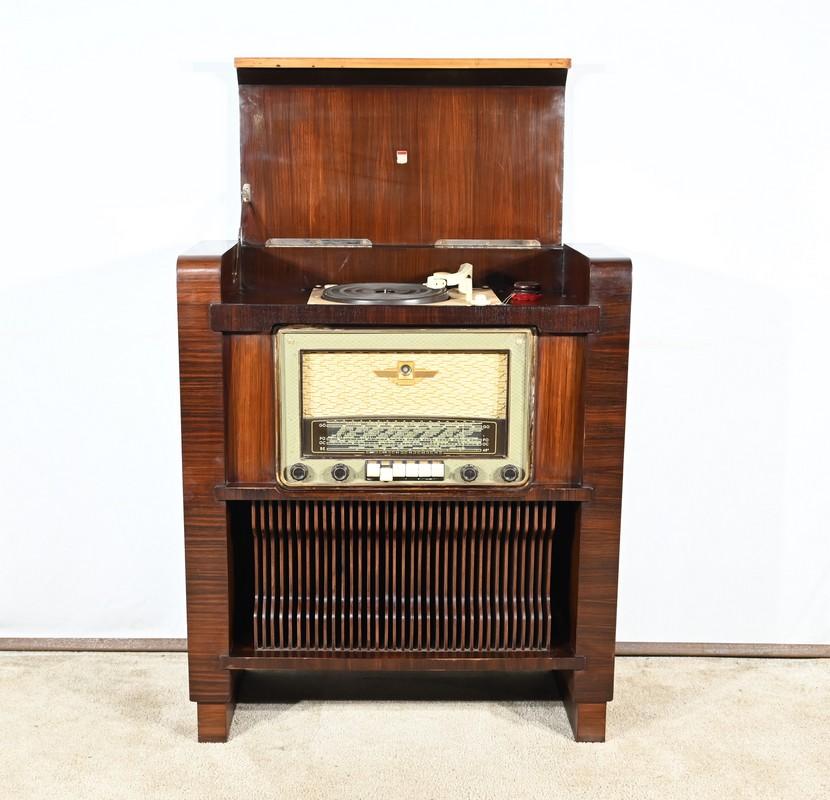 Ce meuble en placage de bois de rose présente une radio à tubes Amplix sur la face avant.
En dessous, un compartiment à disques peut contenir pas moins de 34 disques vinyles.
La partie supérieure est munie d'un rabat articulé en bois de placage et