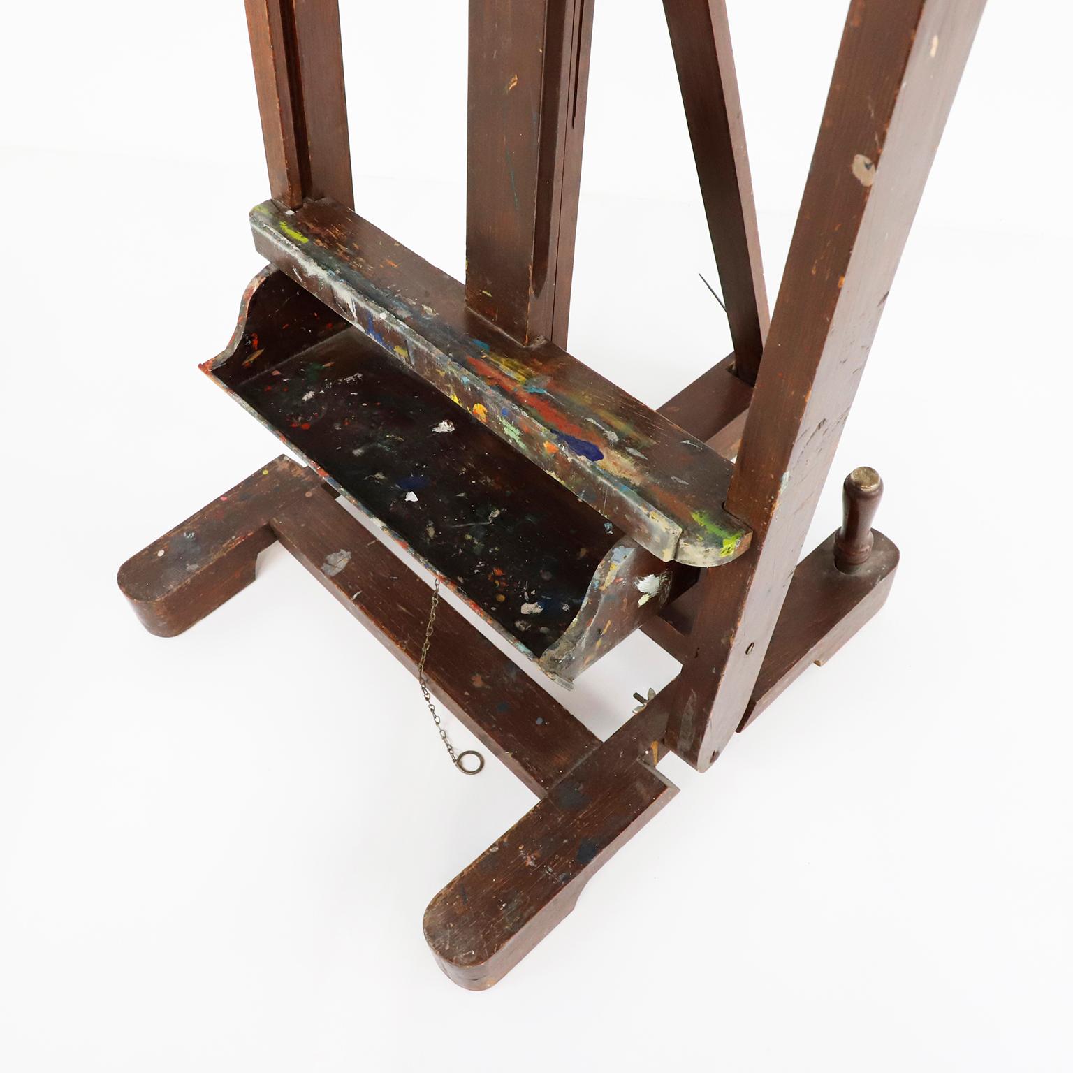 A Mexican wooden adjustable artist easel, circa 1950. This easel has the same design as those currently in the study of Diego Rivera and Frida Kahlo, has a nice old patina, with remnants of artistic creations of past, standing tall, ready for the