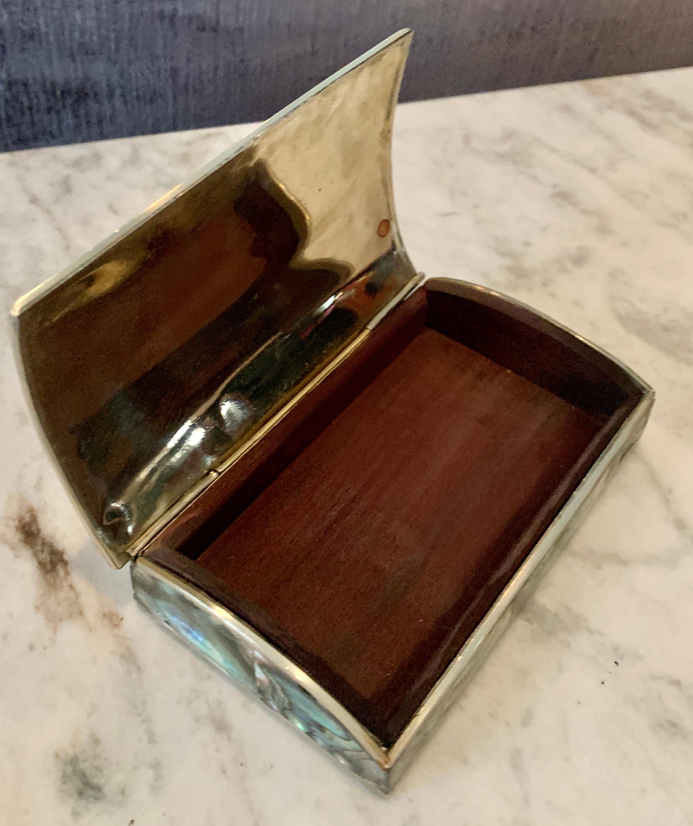 Small Abalone box acquired in Mexico - The sides are brass trim with a wood interior. A compliment to any desk or coffee table - or place to store mementos or jewelry.