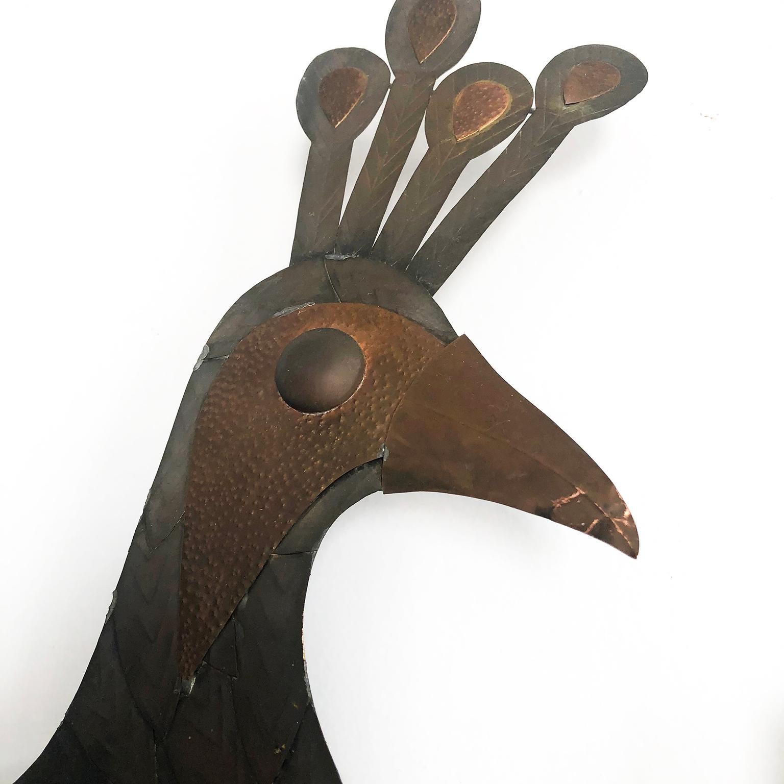We offer this fantastic Mexican brass peacock motif wall mirror, circa 1960. Hand pressed brass with a peacock at top and all-over flower, leaf and scroll detailing. Back hook for hanging, fantastic handmade work.