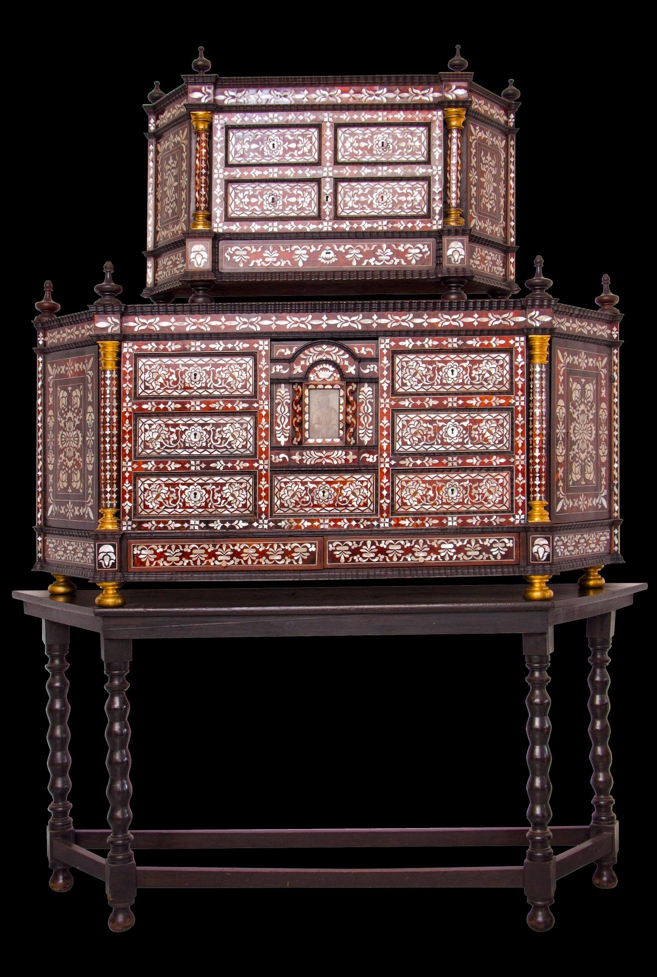 Mexican cabinet, 17th century
This piece of furniture has integrated tortoiseshell and pearl shell marquetry representing geometric and floral motifs, it consists of three trapezoidal shaped envelopes. The middle part on the facade has six drawers