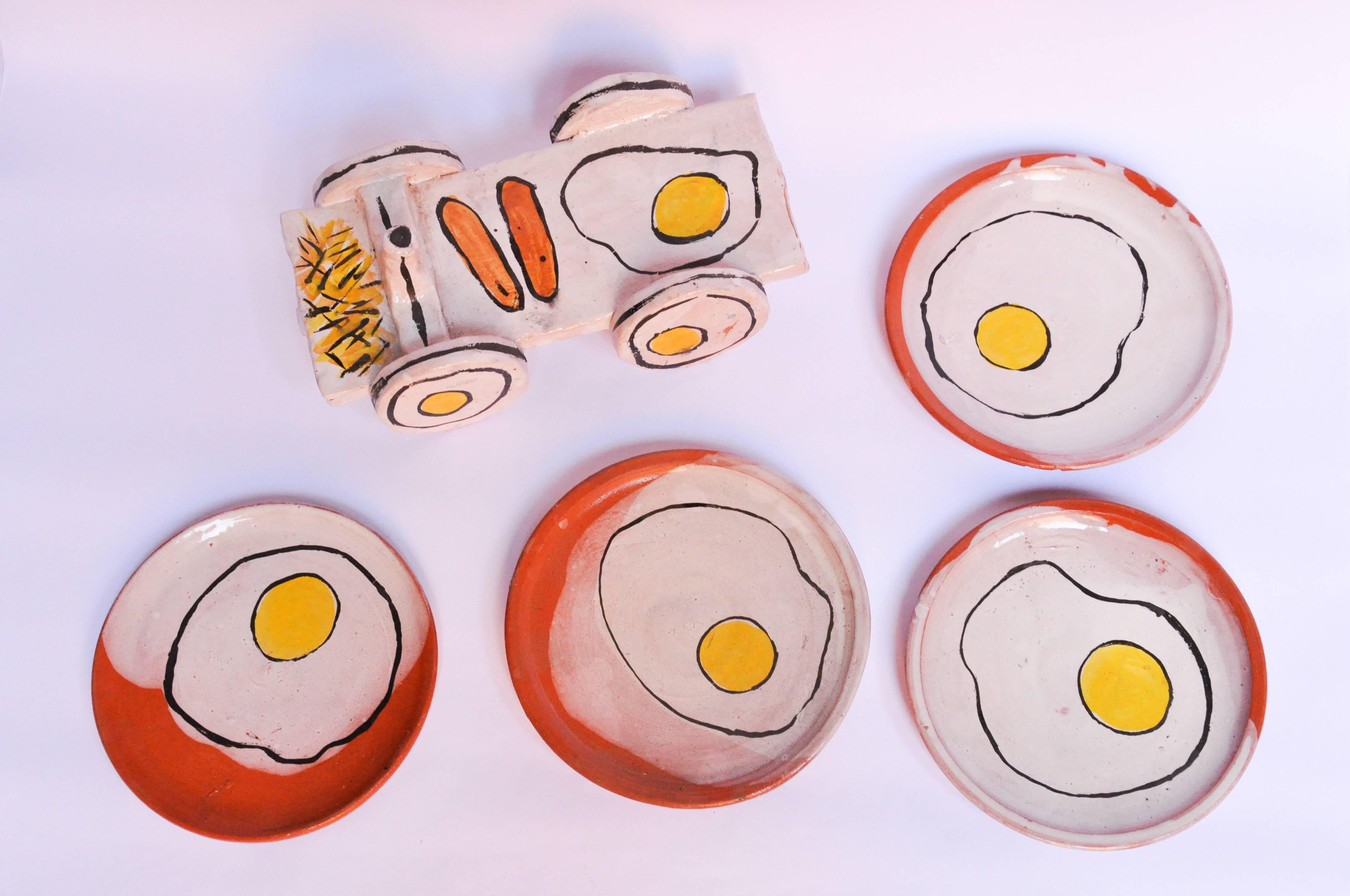 Ceramic four-plate set with modern egg design by Lorenzo Lorenzzo. Cart used for salt and pepper. 

Lorenzo's work alludes to his favorite meal, breakfast, creating a modern design for this plate collection.