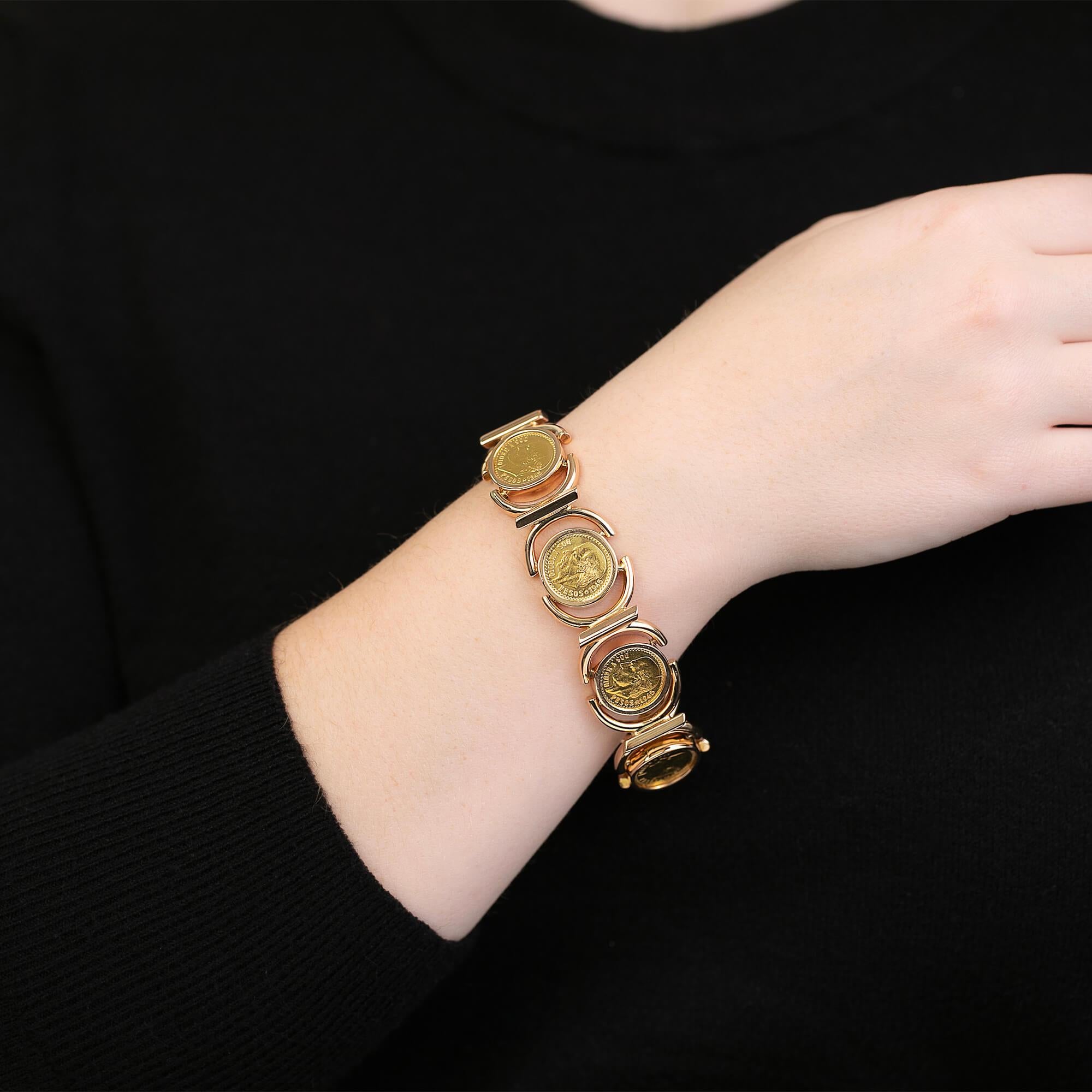 A Mexican made yellow gold bracelet, featuring a series of 1945 Mexico 2.50 peso featuring Dos Y Medio, held within a bezel set frame. Each frame has two hinged surrounds connecting each frame to form this unique bracelet. Secured with a hidden box