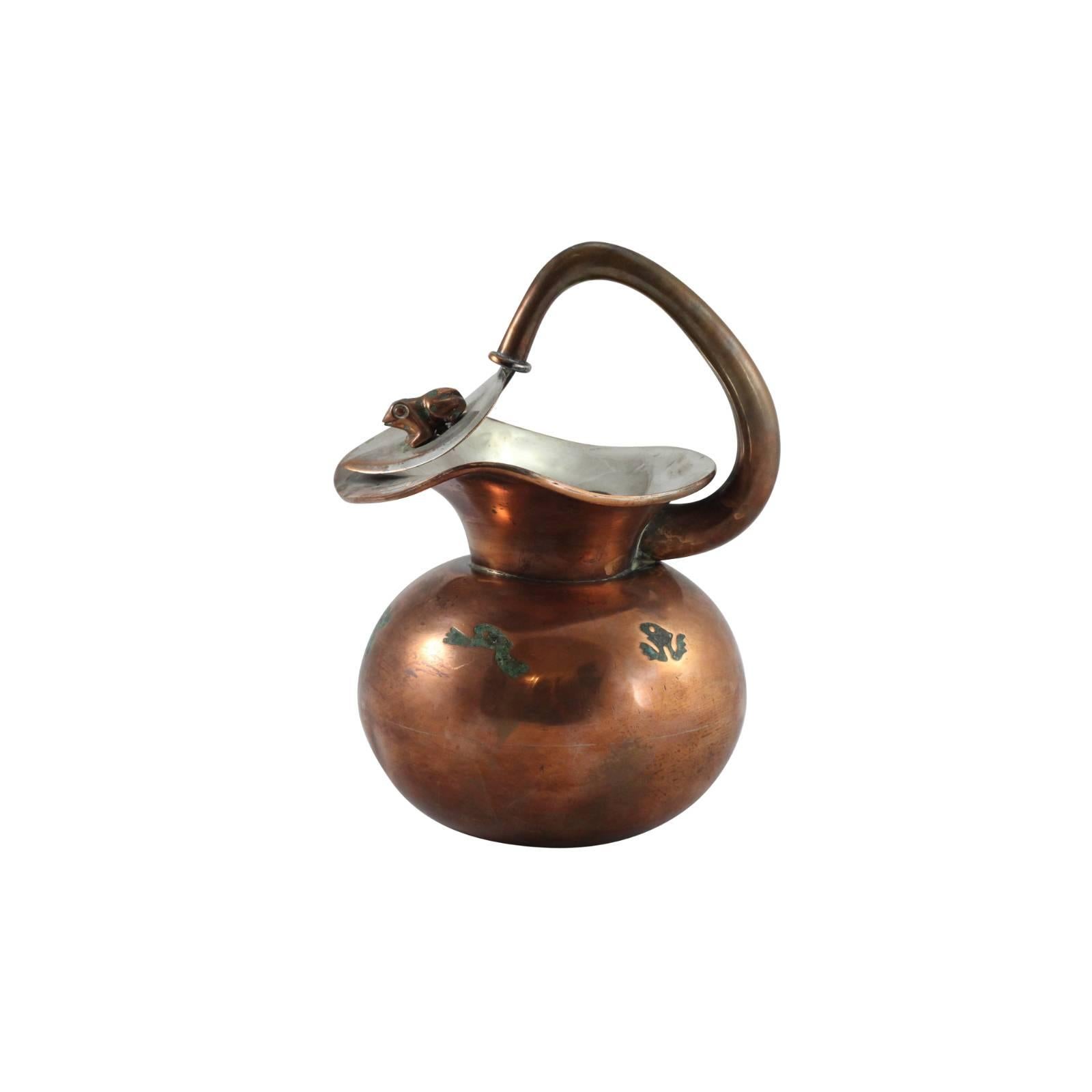 This Mexican pitcher by Chato Castillo, Taxco is sure to be a unique addition to your collection. With its distinct Mexican design in copper and brass with curious malachite frog details, it may be the perfect thing for your upcoming garden party