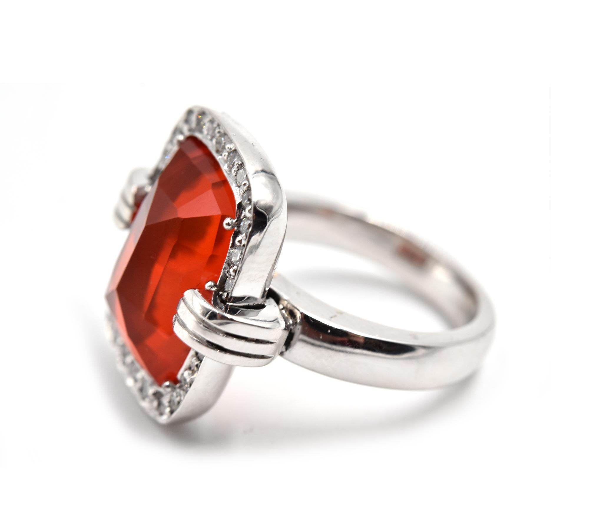 Designer: custom design
Material: 14k white gold
Gemstones: one 6.64 carat cushion cut Mexican fire opal and diamonds
Diamonds: 25 round brilliant cut diamonds = 1.00 carat total weight
Color: G
Clarity: SI1
Dimensions: ring top is 3/4-inch long and