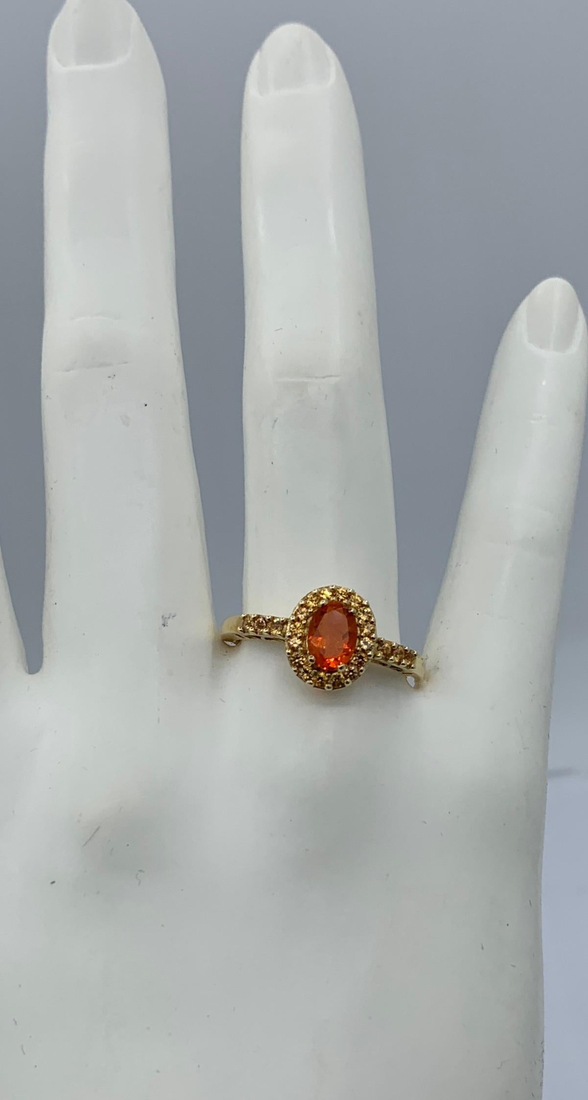 This is a gorgeous estate Mexican Fire Opal Ring with a halo of beautiful Citrine gems which also extend down the band.  The ring is 14 Karat Yellow Gold.  The sparkling oval Mexican Opal has the sparkling orange fire that we love in the Mexican