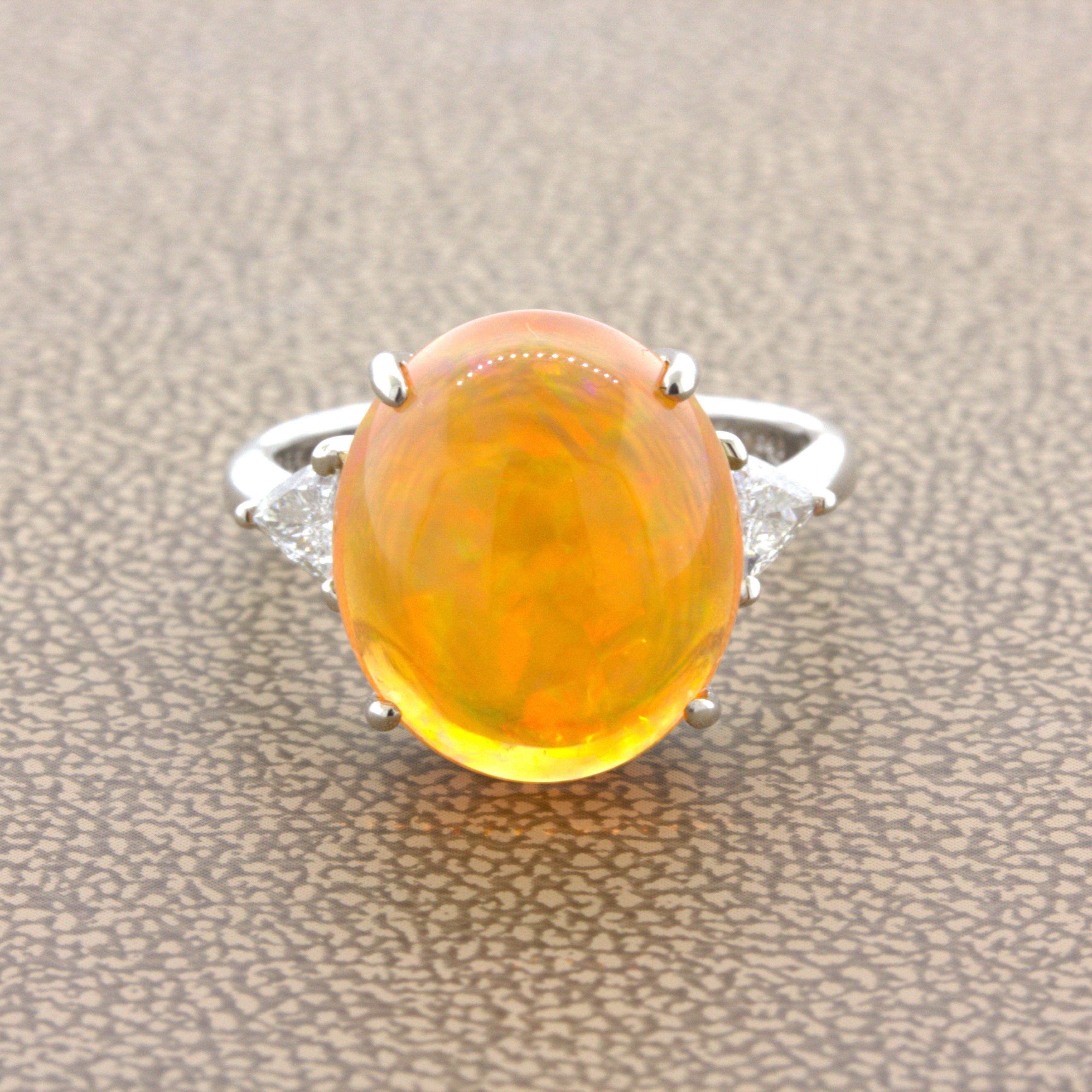A classic 3-stone ring featuring a fine Mexican fire opal. It weighs an impressive 7.08 carats and has a vibrant orange body color with excellent-play-of-color as well. Flashes of red, green, orange, and yellow can all be seen scintillating across